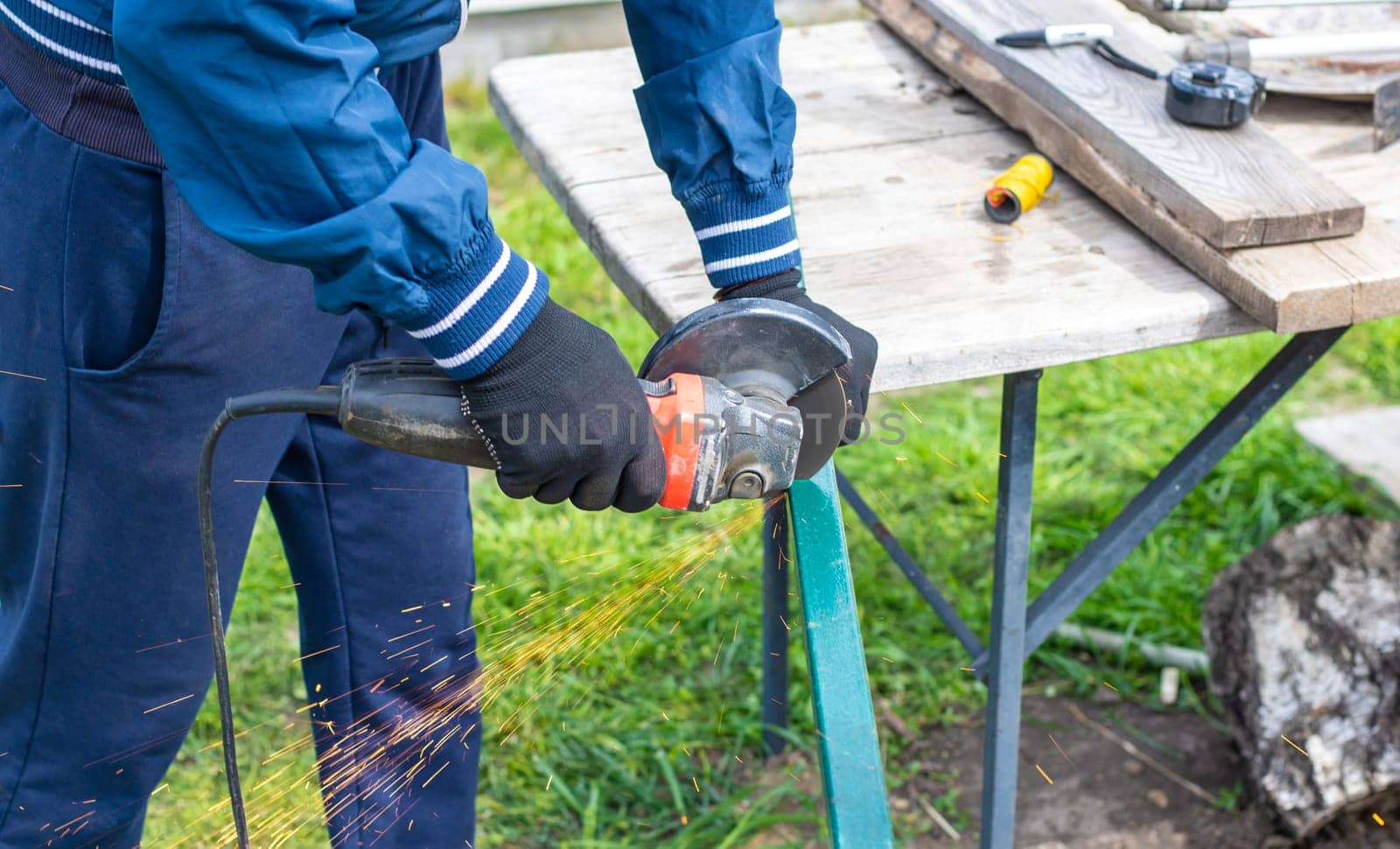A man works with a grinder on metal. Selective focus. people.