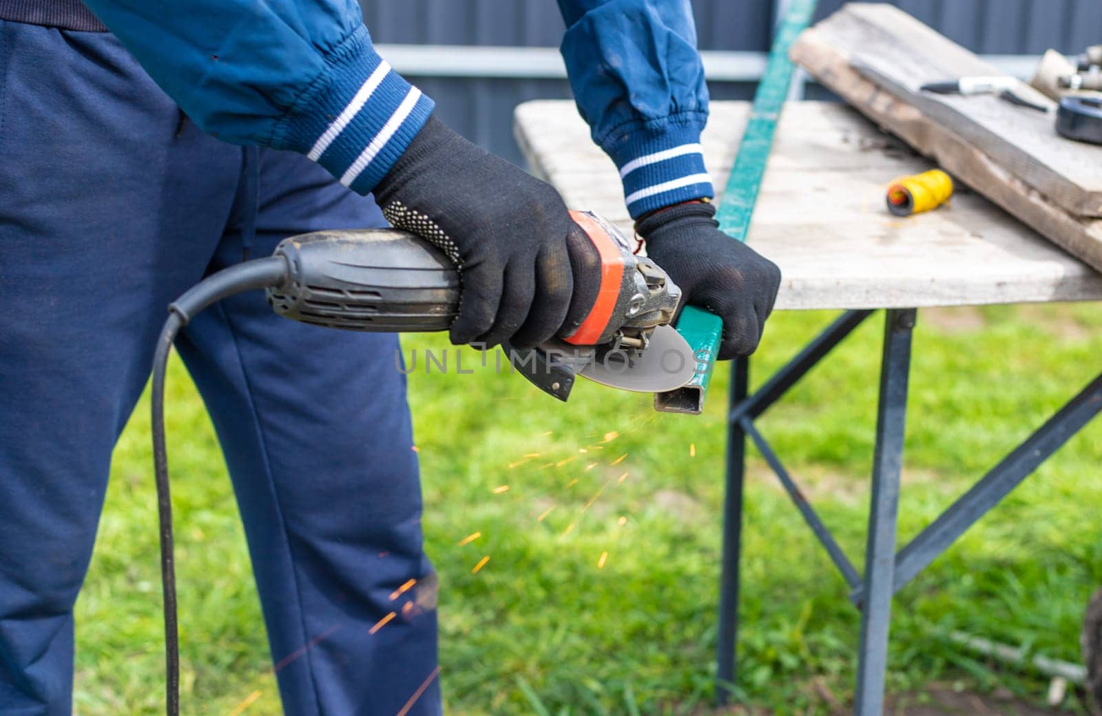 A man works with a grinder on metal. Selective focus. people.