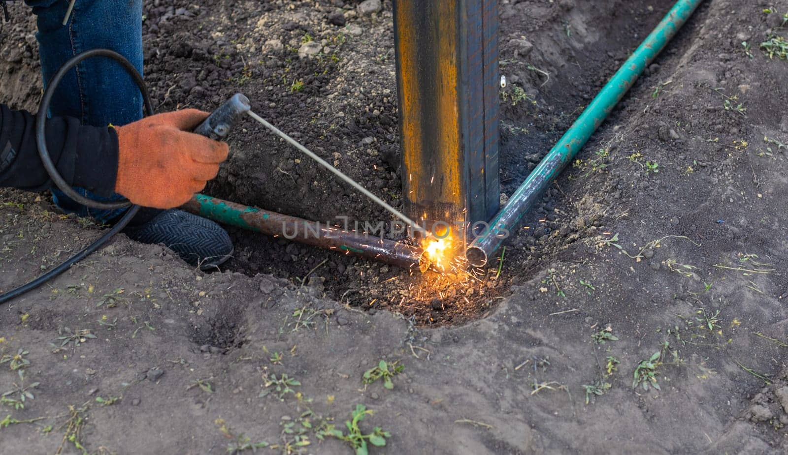 A man doing welding work. Selective focus. People.