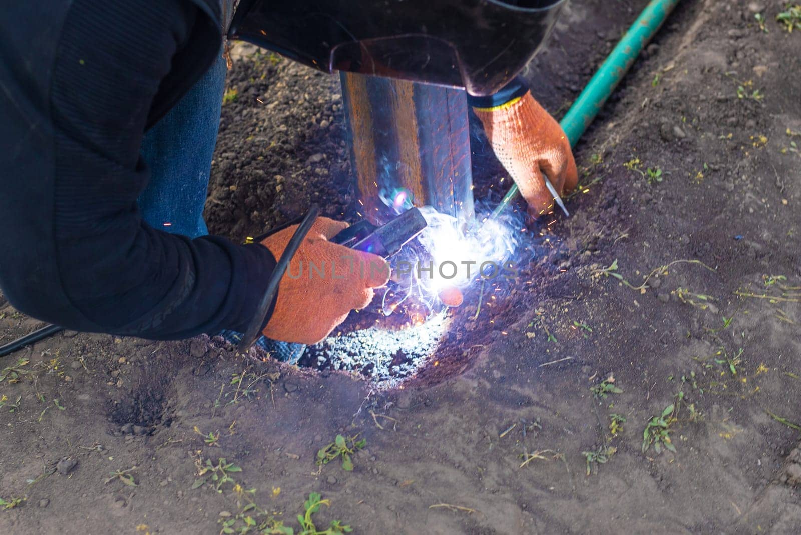 A man doing welding work. Selective focus. People.