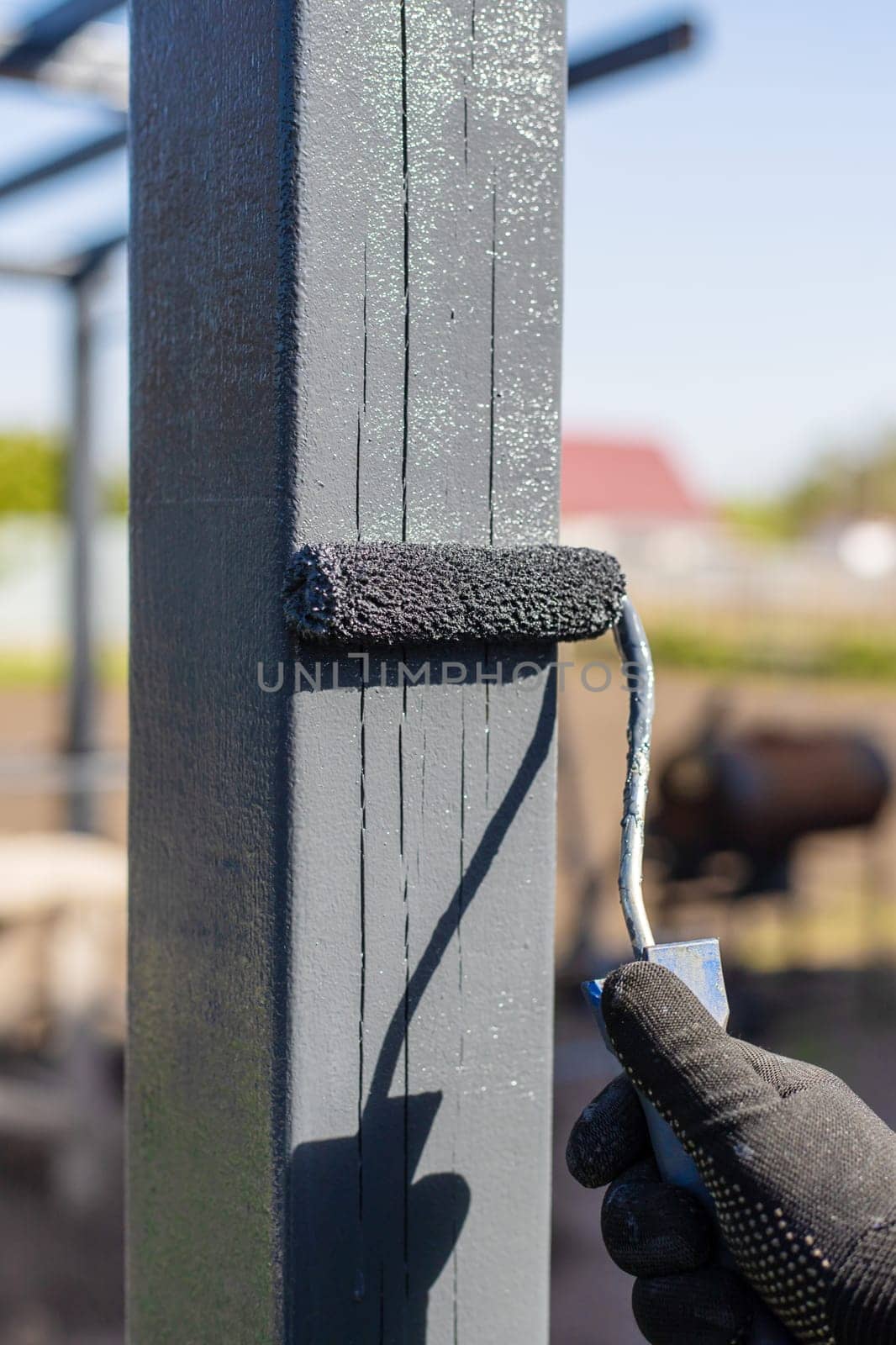 Man painting wooden poles. Selective focus. people.