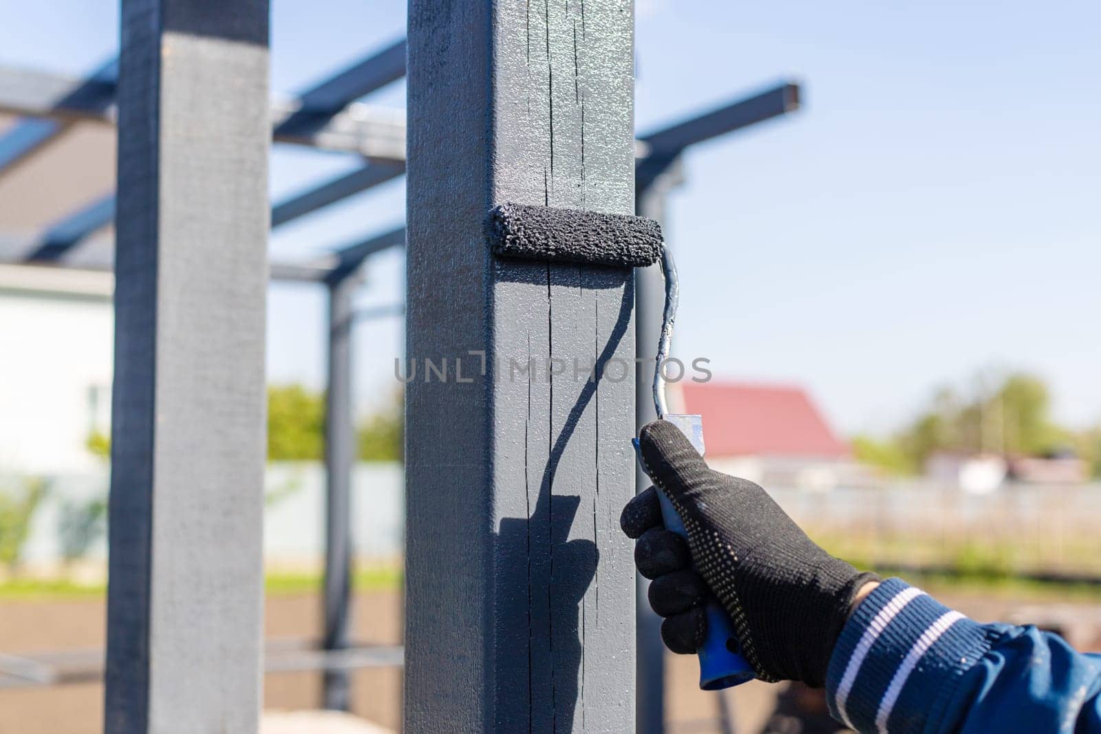Man painting wooden poles. Selective focus. people.