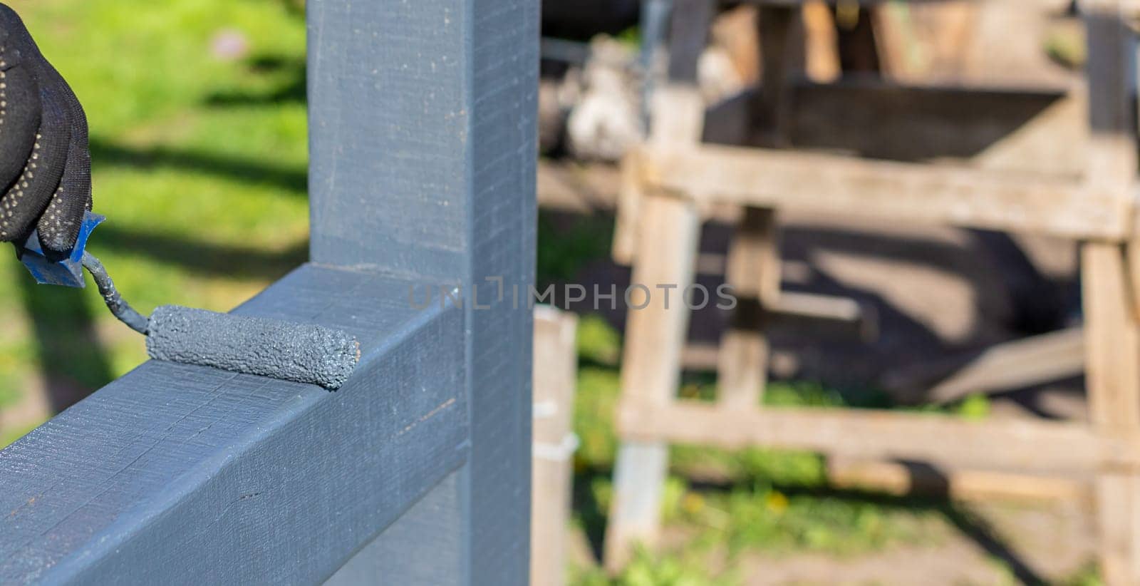 Man painting wooden poles. Selective focus. people.