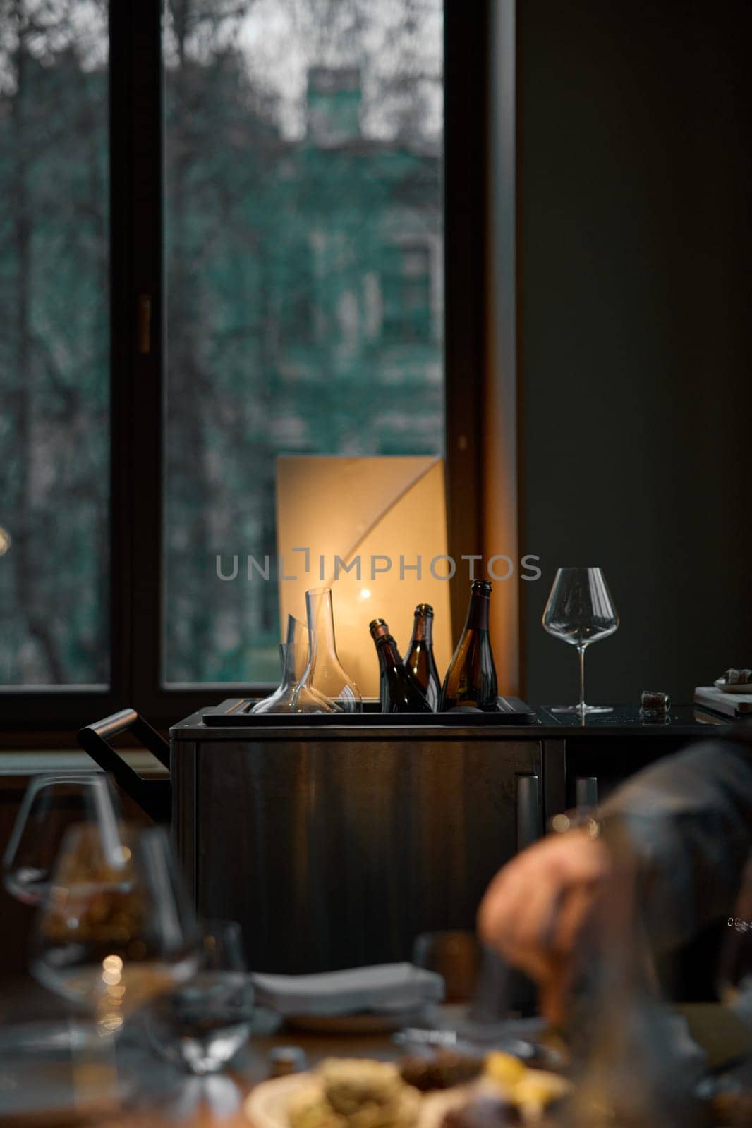 Several bottles of champagne are cooled in a niche with ice in the restaurant, local lighting, wine cabinet, decanters for sparkling wine. High quality photo