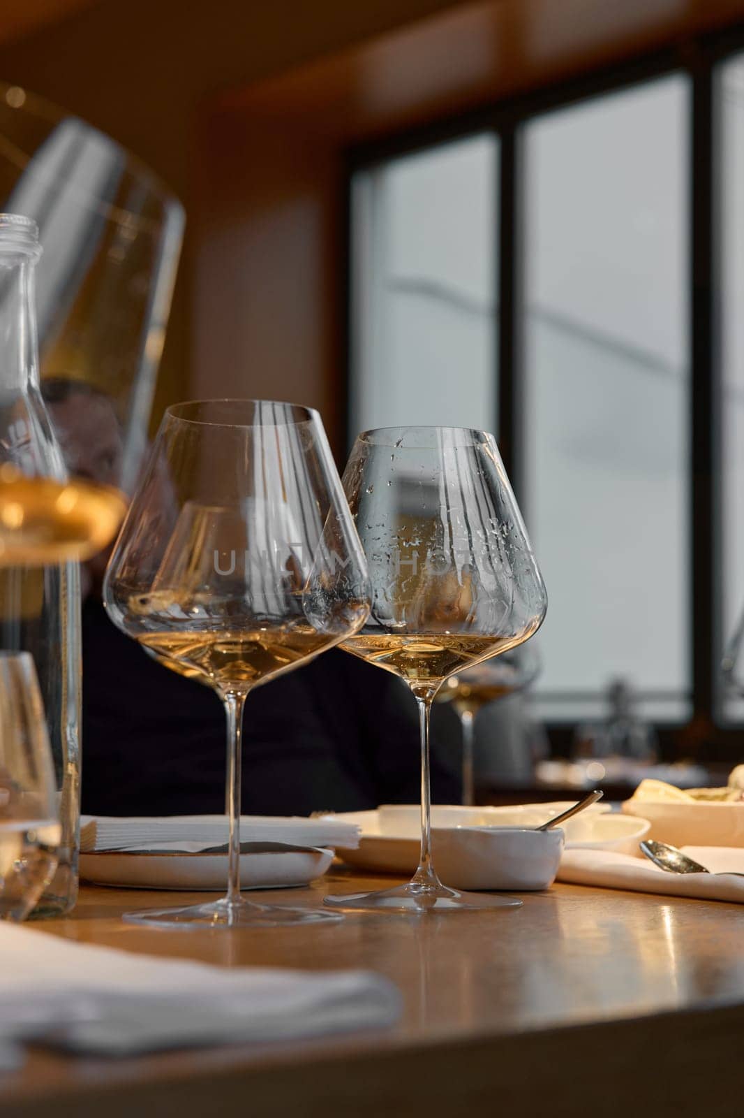 A glass of sparkling wine in close-up, Champagne tasting, Wine glasses are on the table, stylish table setting, sparkling wine bubbles, oysters and sea urchins, special sauce. High quality photo
