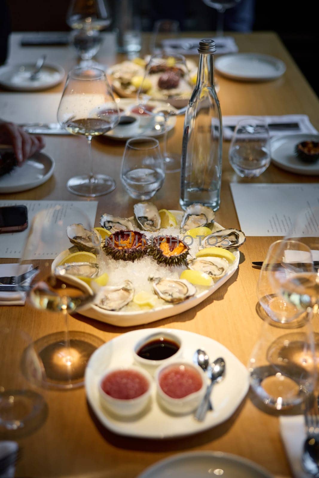 Champagne tasting, Wine glasses are on the table, stylish table setting, sparkling wine bubbles, oysters and sea urchins, special sauce. High quality photo