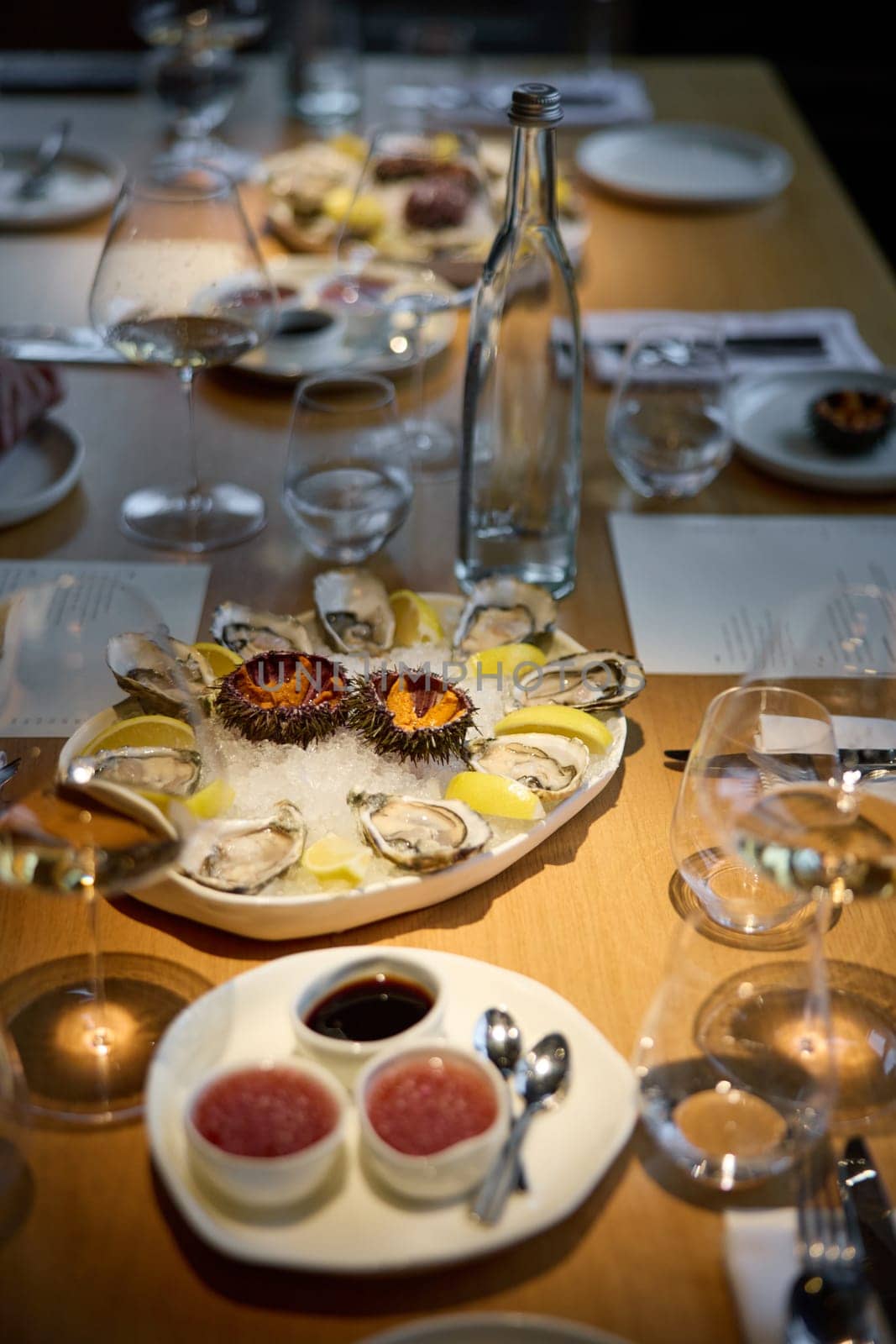 Champagne tasting, Wine glasses are on the table, stylish table setting, sparkling wine bubbles, oysters and sea urchins, special sauce. High quality photo
