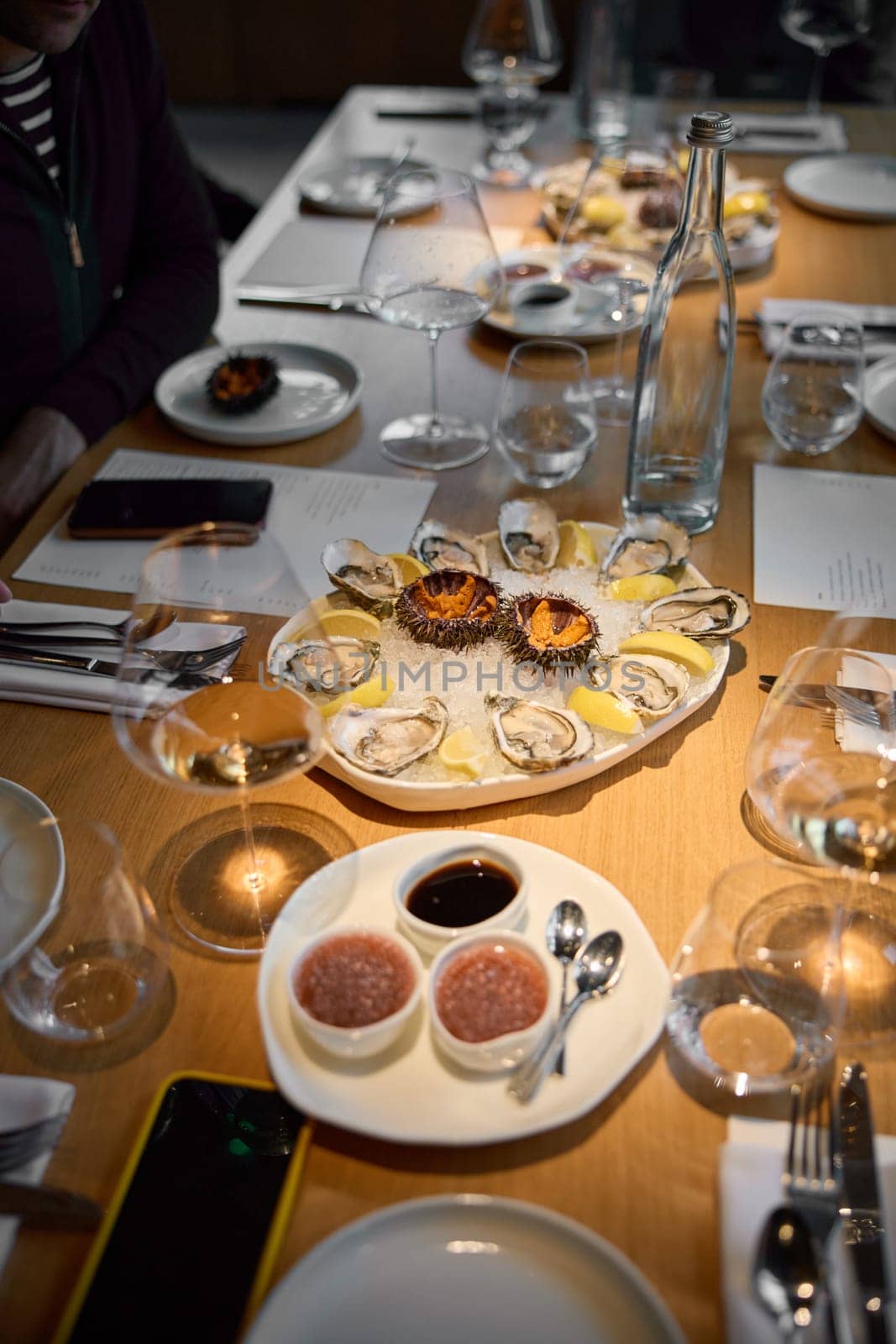 Champagne tasting, Wine glasses are on the table, stylish table setting, sparkling wine bubbles, oysters and sea urchins, special sauce. High quality photo