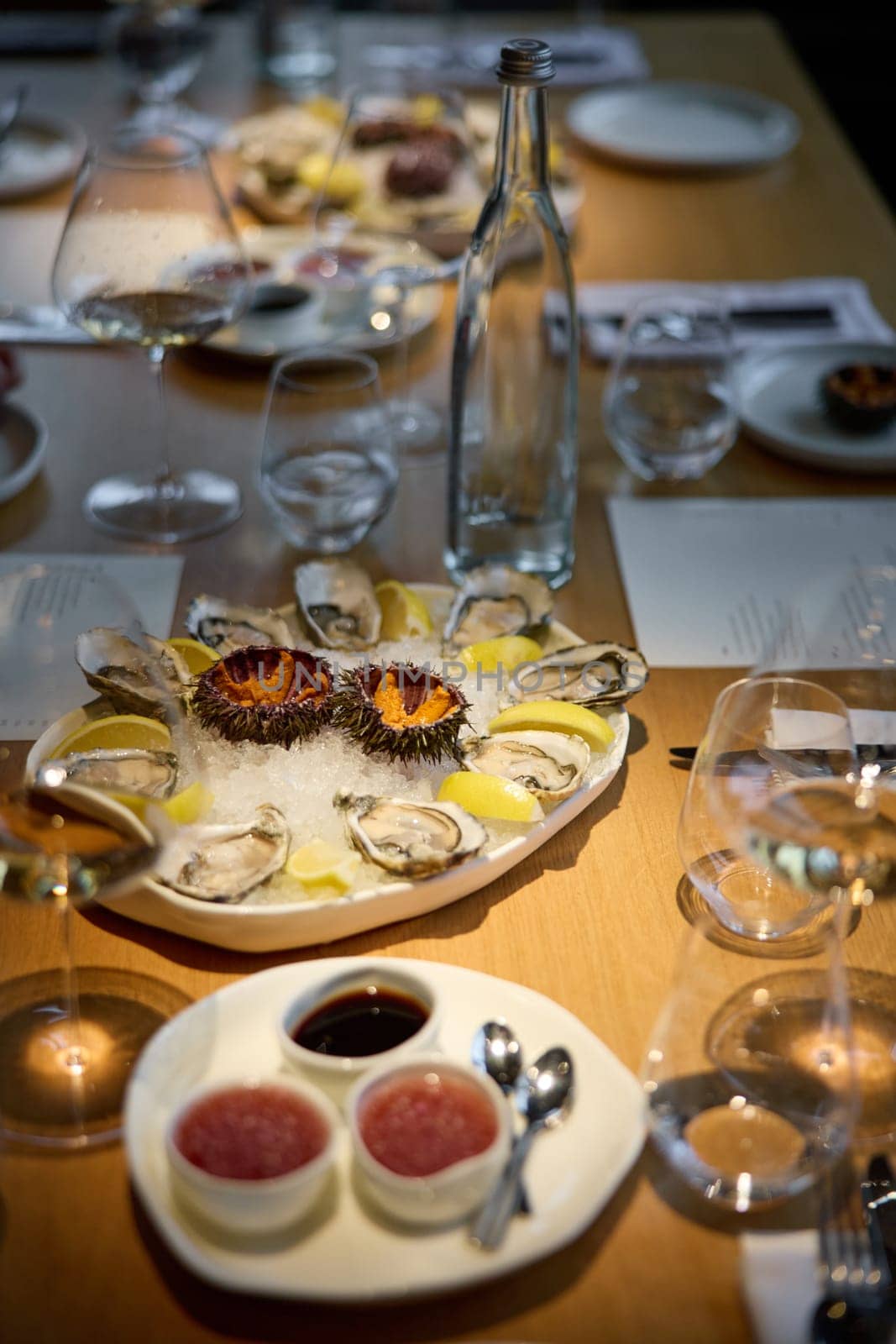 Champagne tasting, Wine glasses are on the table, stylish table setting, sparkling wine bubbles, oysters and sea urchins, special sauce. High quality photo