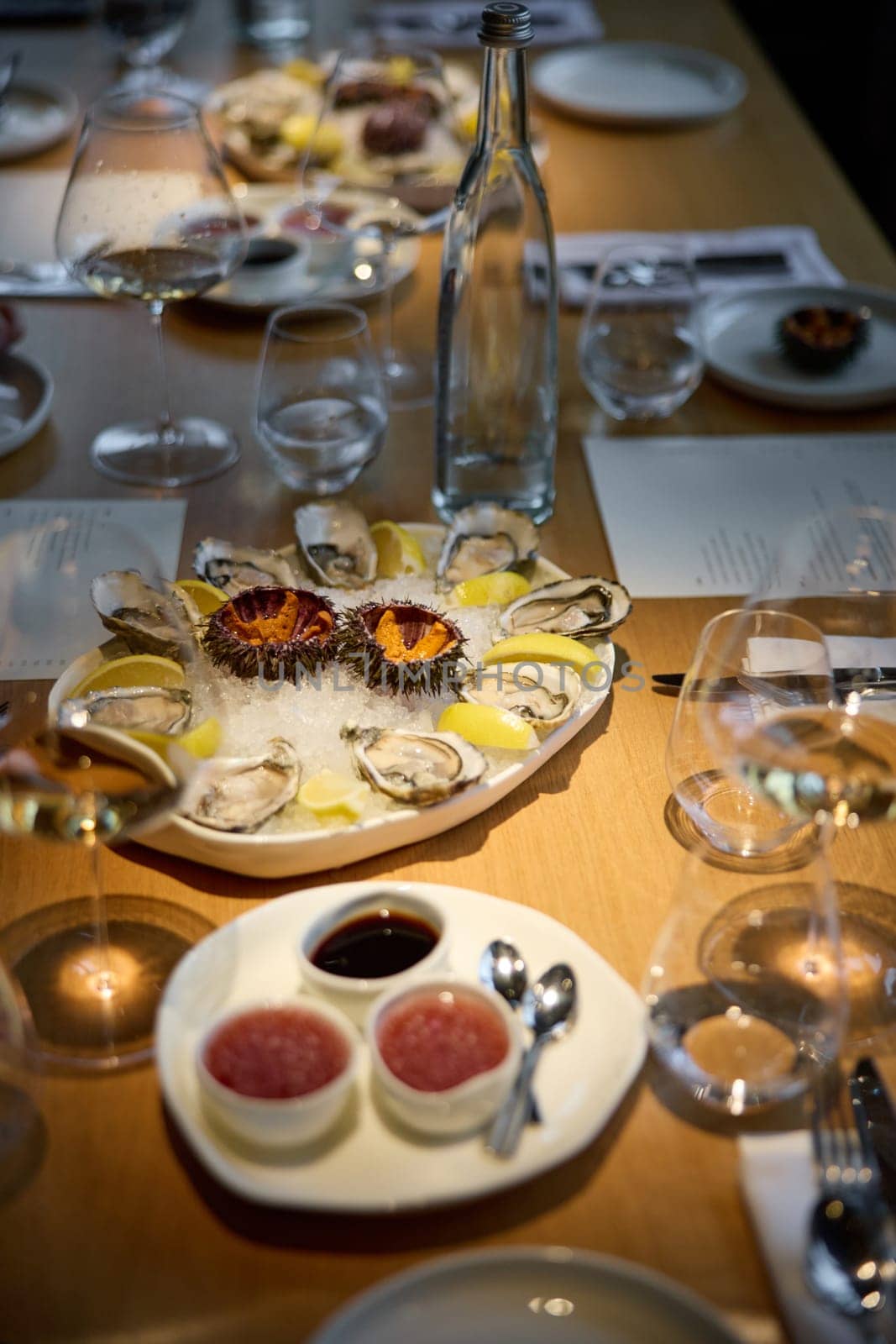 Champagne tasting, Wine glasses are on the table, stylish table setting, sparkling wine bubbles, oysters and sea urchins, special sauce. High quality photo