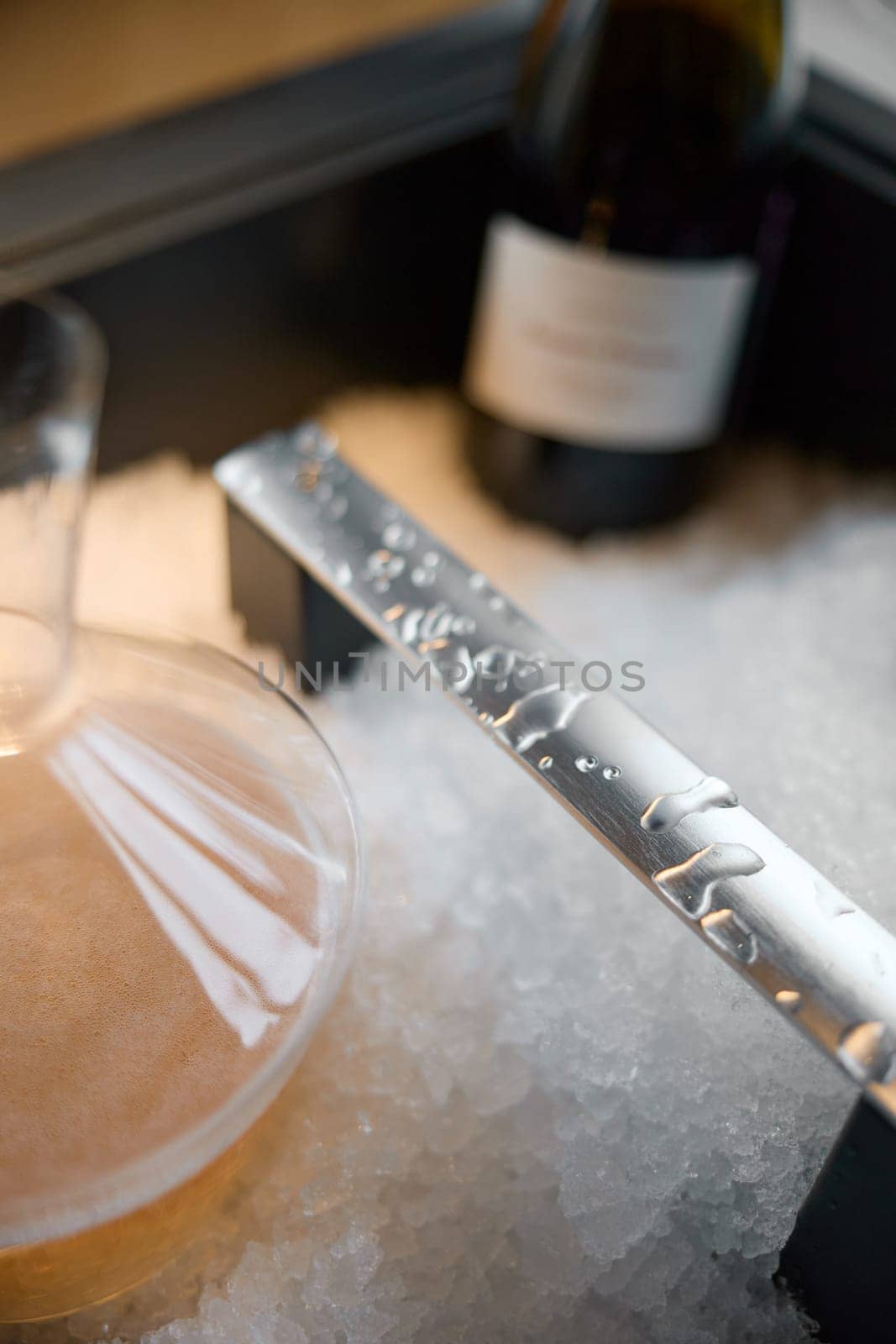 Russia, St.Petersburg, 29 April 2025: Several bottles of champagne brand Bonnet-Ponson are cooled in a niche with ice in the restaurant, local lighting, wine cabinet, decanters for sparkling wine. High quality photo