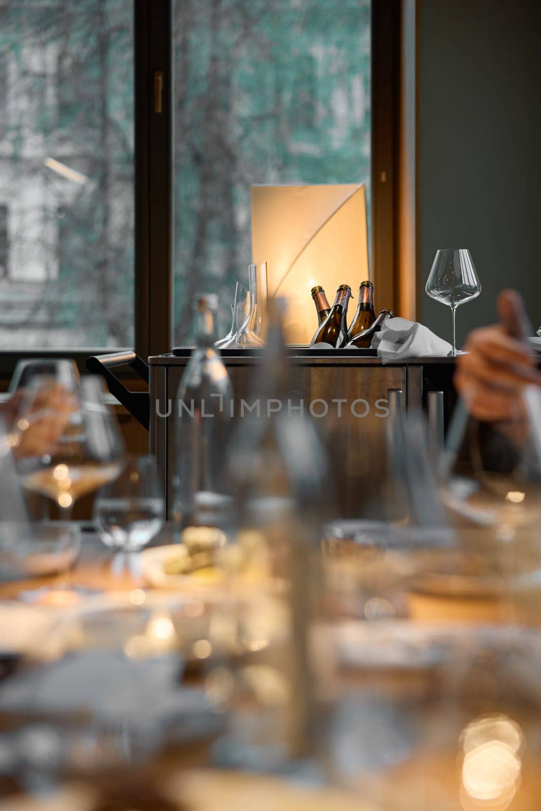 Several bottles of champagne are cooled in a niche with ice in the restaurant, local lighting, wine cabinet, decanters for sparkling wine. High quality photo