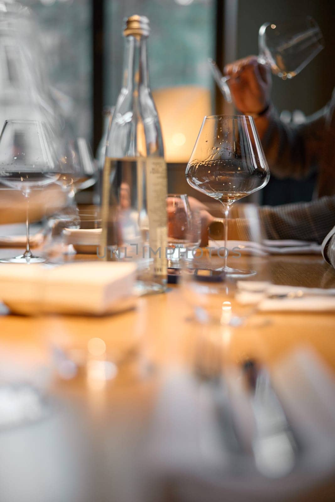 Champagne tasting, Wine glasses are on the table, stylish table setting, A man's hand holds a beautiful elegant glass with rose sparkling wine, an intimate light, a plate with oysters and lemon. High quality photo