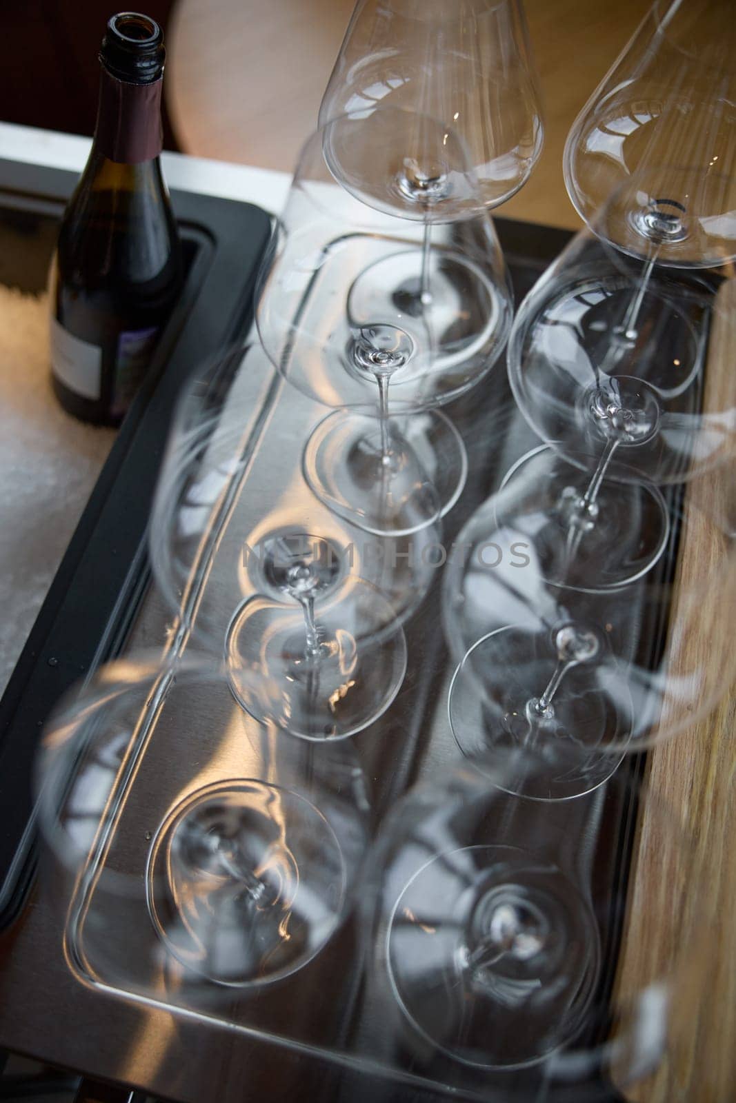 Clean wine glasses are on the table of a special wine cabinet, stylish table setting, ice, bottle of sparkling wine, light from window, decoder and degasser. High quality photo