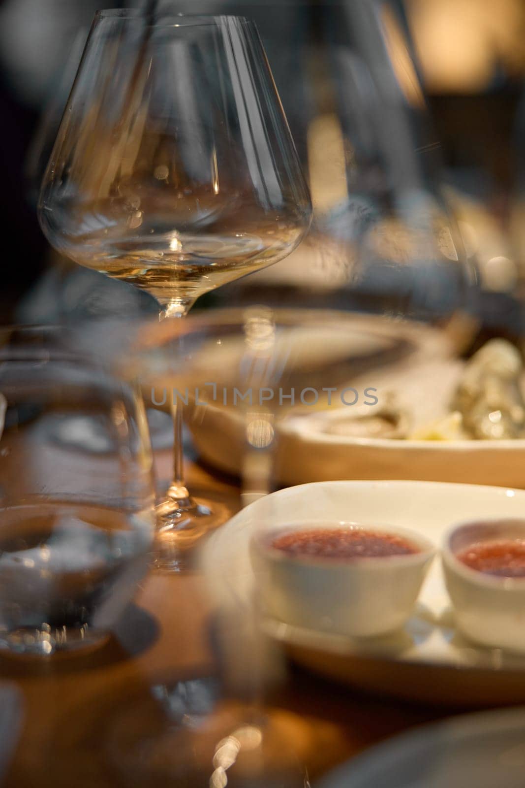 A glass of sparkling wine in close-up, Champagne tasting, Wine glasses are on the table, stylish table setting, sparkling wine bubbles, oysters and sea urchins, special sauce. High quality photo