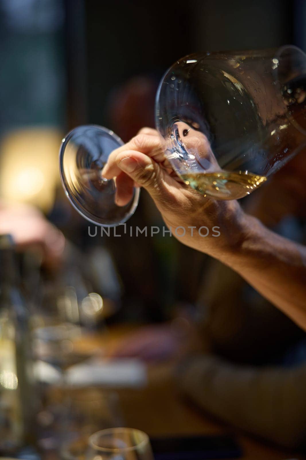Champagne tasting, Wine glasses are on the table, stylish table setting, A man's hand holds a beautiful elegant glass with rose sparkling wine, an intimate light, a plate with oysters and lemon. High quality photo