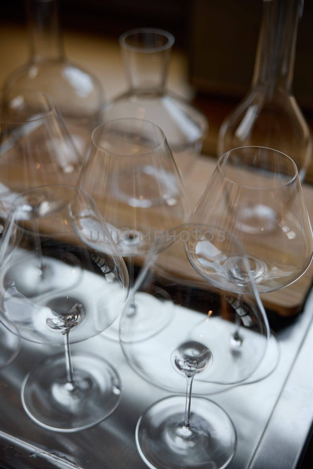 Clean wine glasses are on the table of a special wine cabinet, stylish table setting, ice, bottle of sparkling wine, light from window, decanter and degasser. High quality photo