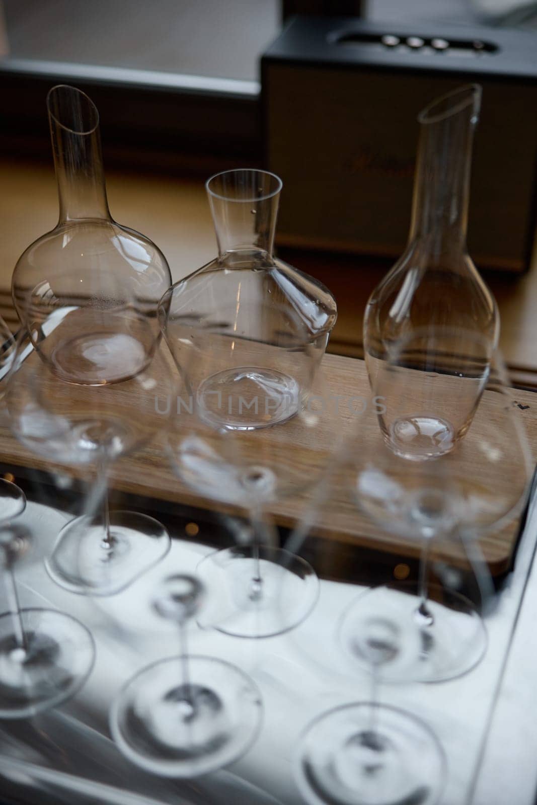 Clean wine glasses are on the table of a special wine cabinet, stylish table setting, ice, bottle of sparkling wine, light from window, decanter and degasser. High quality photo