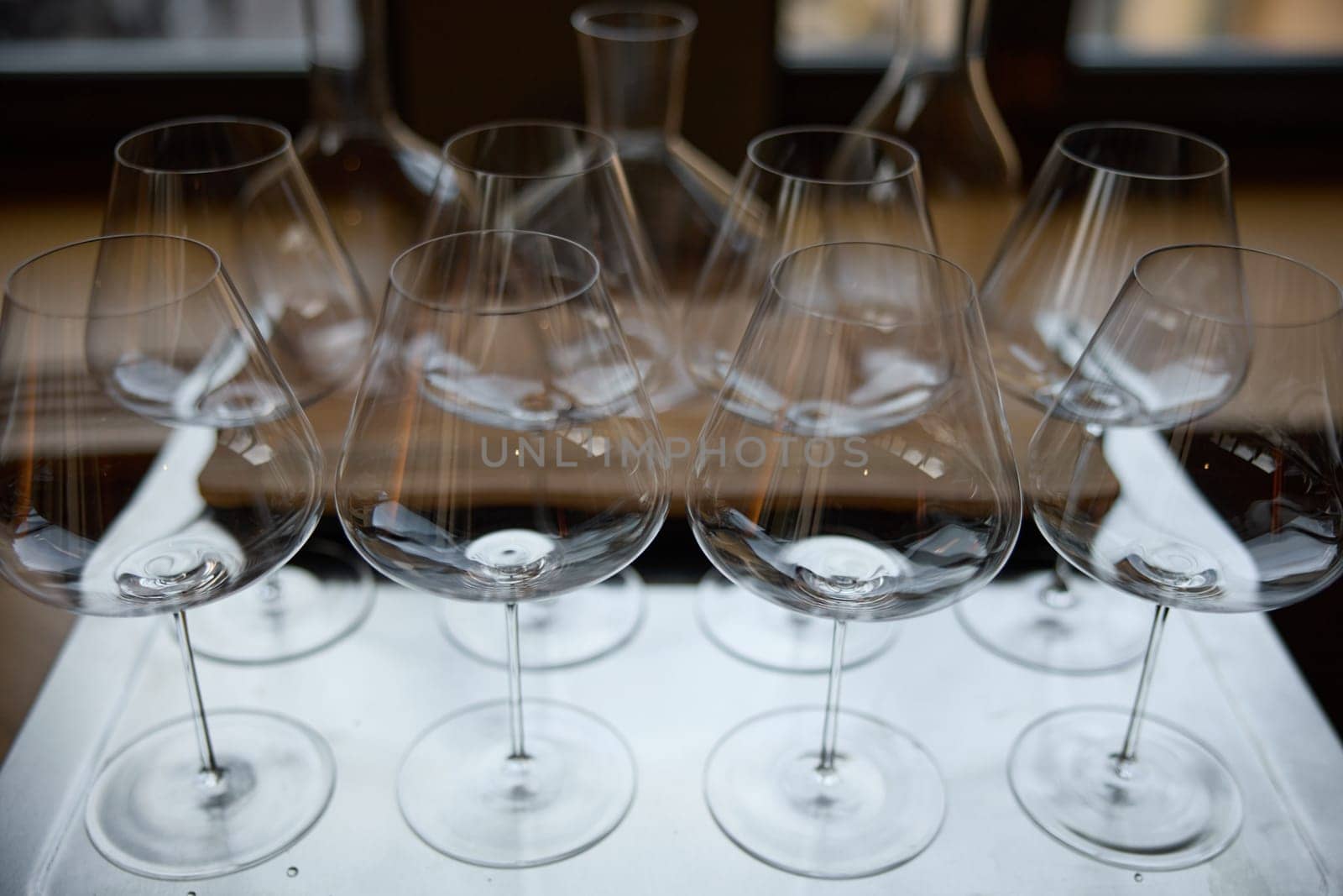 Clean wine glasses are on the table of a special wine cabinet, stylish table setting, ice, bottle of sparkling wine, light from window, decanter and degasser. High quality photo