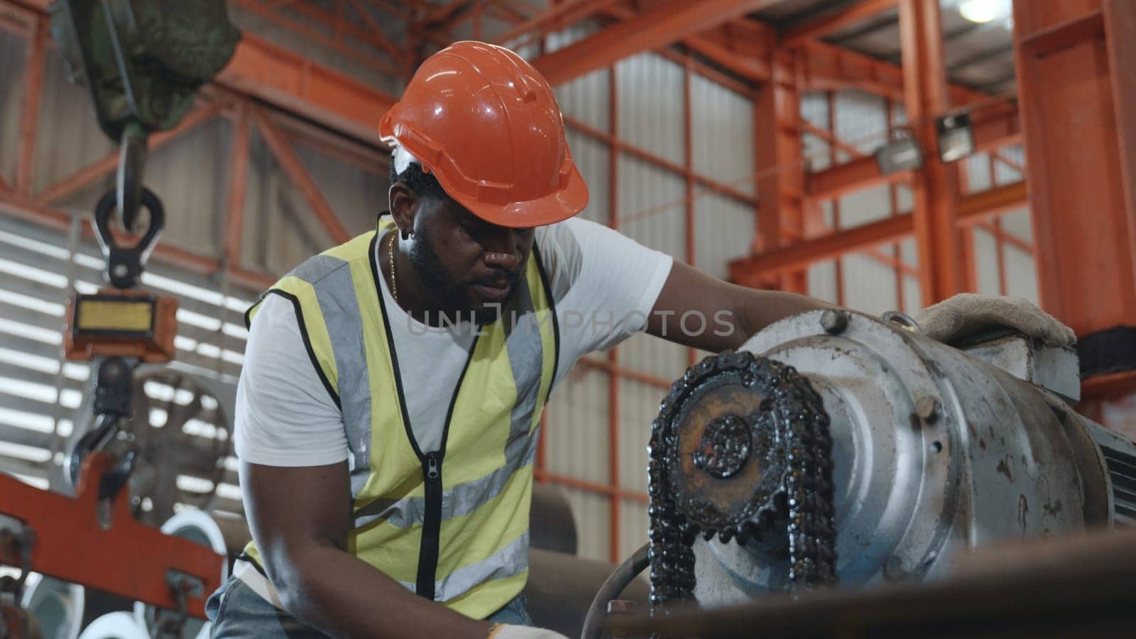 Engineer or operator wearing a safety suit maintaining machine in the industrial factory, service technicain worker operating tighten the nut repair machinery at metal sheet factory