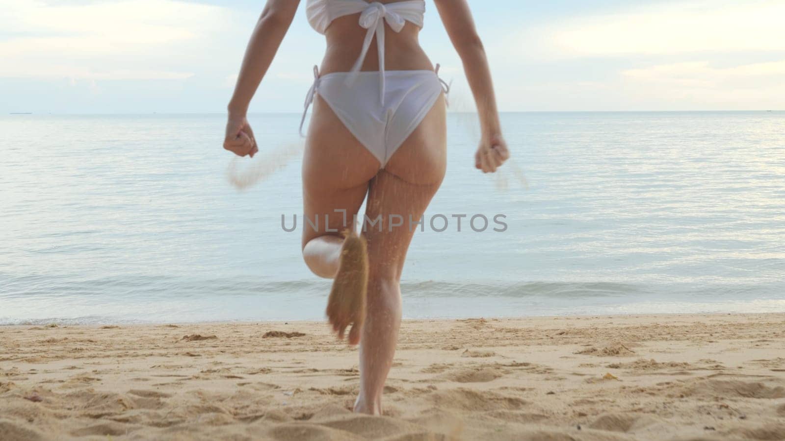 Back view, Young beautiful woman wearing bikini swimsuit running into tropical on sand beach to water, Happy Asian female have fun she run holiday outside, Summer travel vacation concept