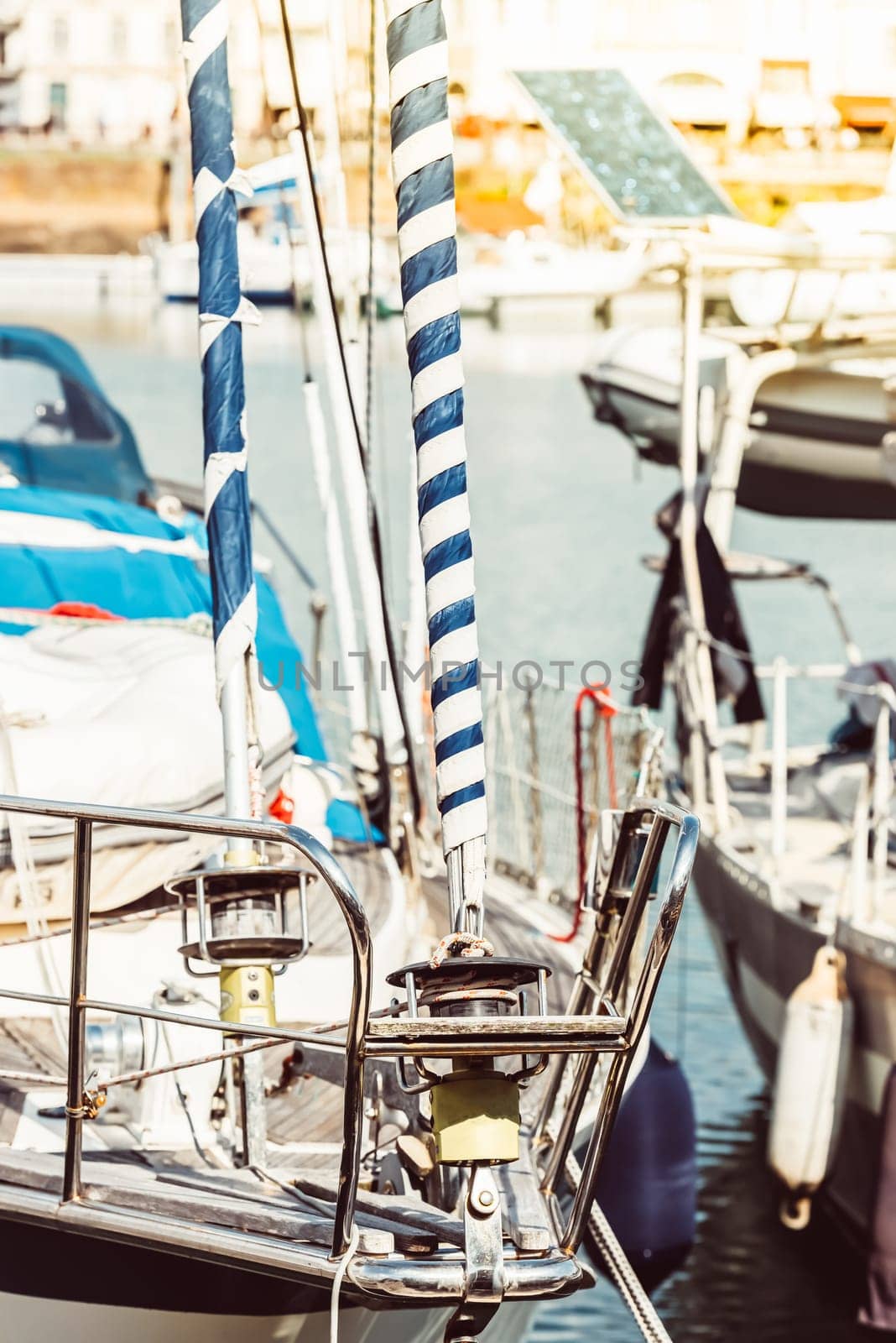 Sailboat deck with striped sails and harbor background, 