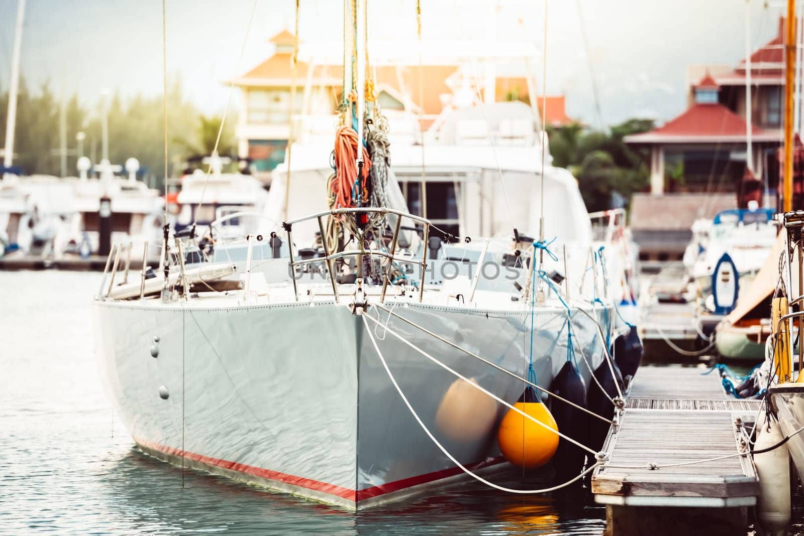 Sailboats moored at marina in bright sunlight with calm water, background, 
