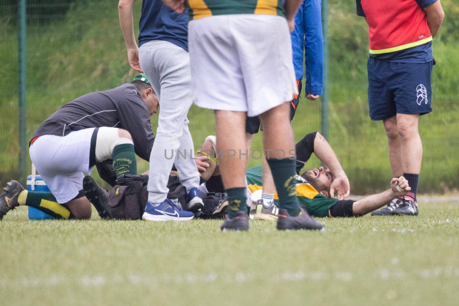 3 may 2025, lisbon. Portugal - oeiras vs ag - medical staff attending to injured rugby player on the field during a rugby match, surrounded by concerned teammates and staff
