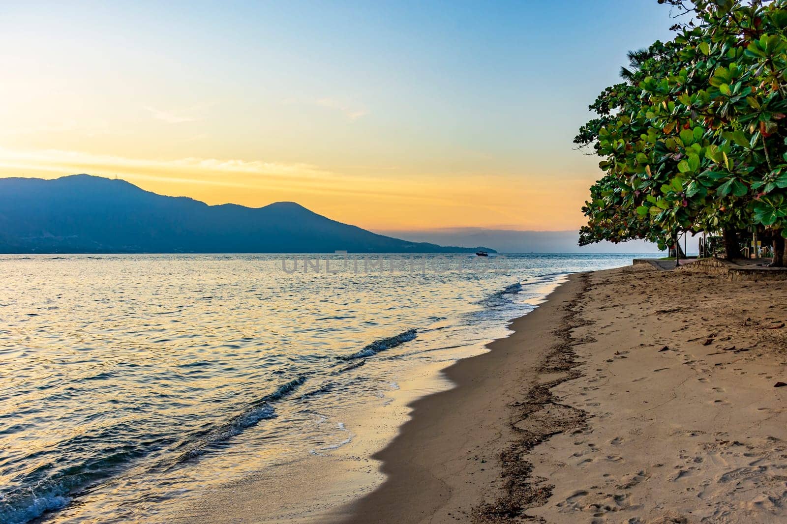 Beach in the urban area of ​​Ilhabela island during sunset