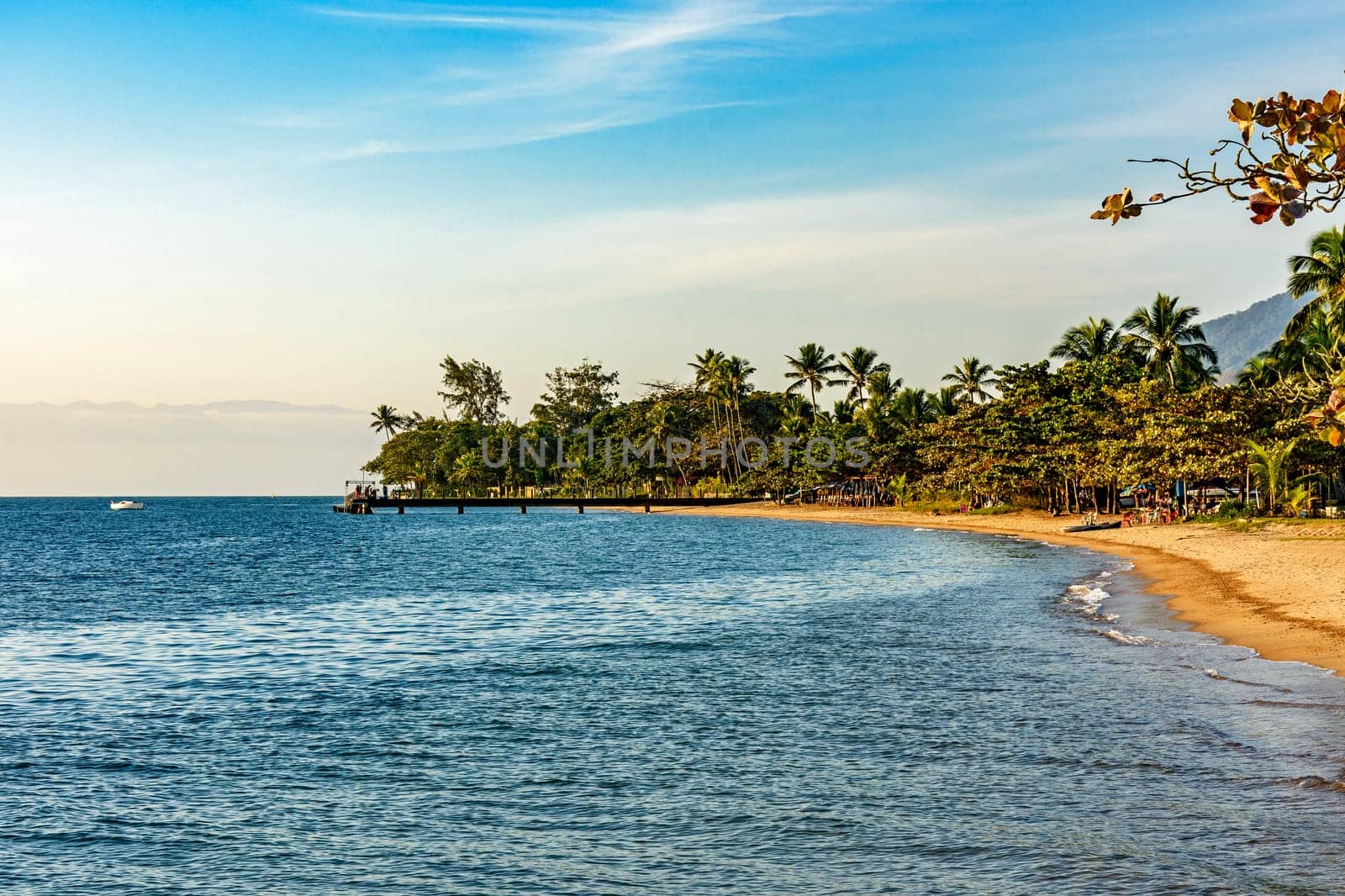 Late afternoon on the beach in the urban area of ​​Ilhabela island during sunset