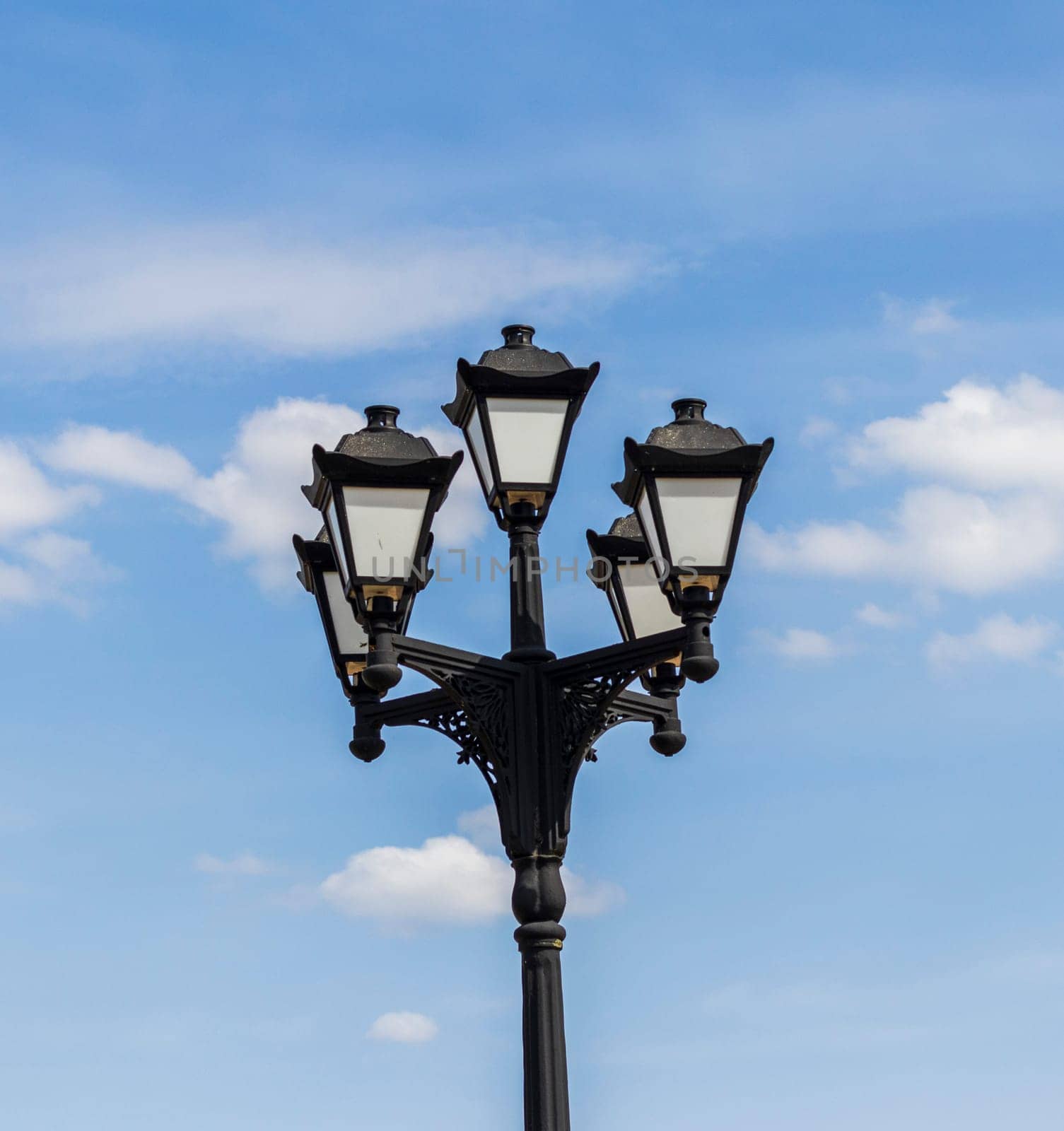 Vintage, cast iron street lamp post with cloudy background