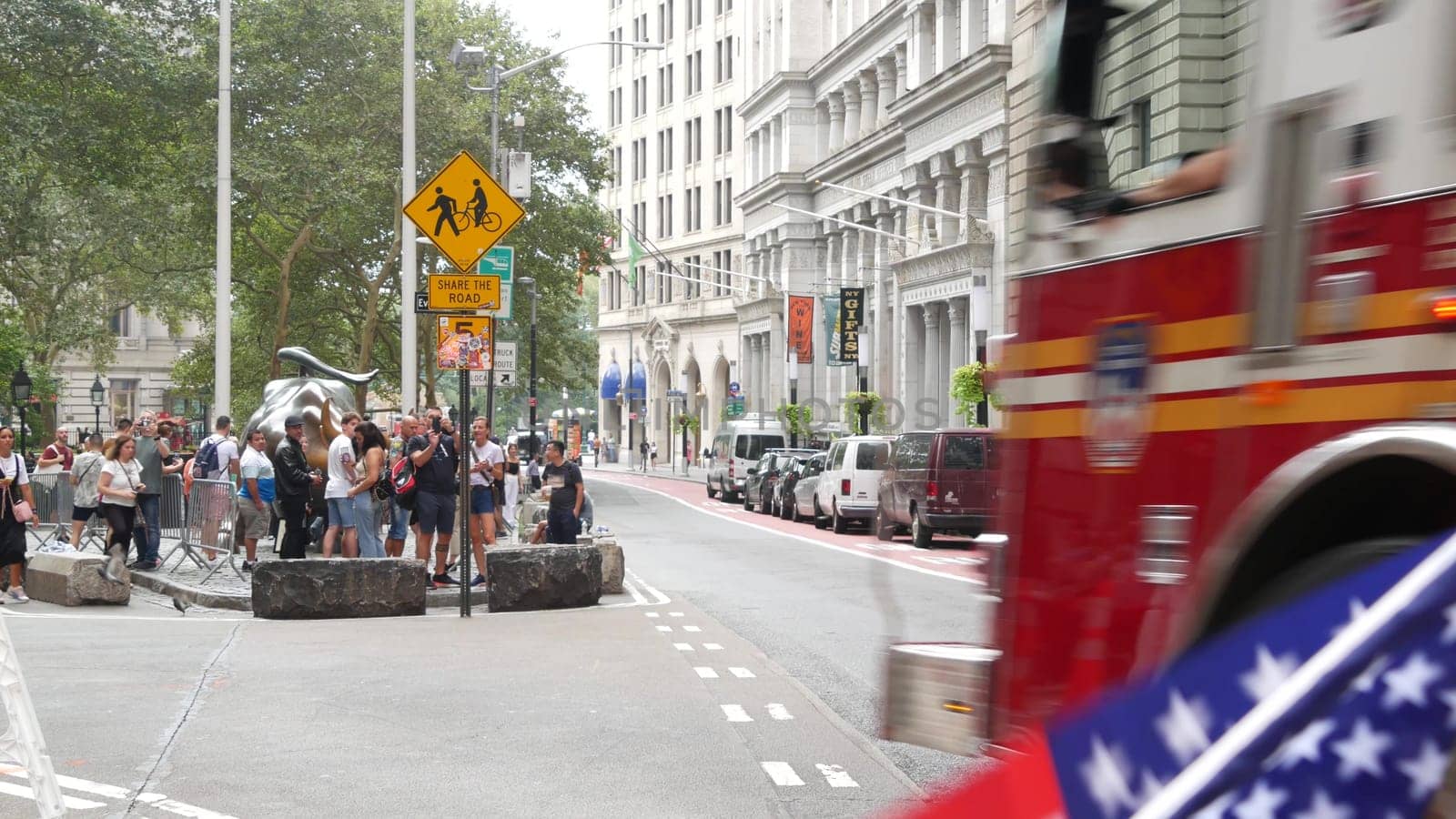 New York City, United States - 9 Sept 2023: NYFD car, USA fire department truck, american firefighters vehicle or fire fighter engine, Broadway, Manhattan Downtown financial district. Charging Bull.