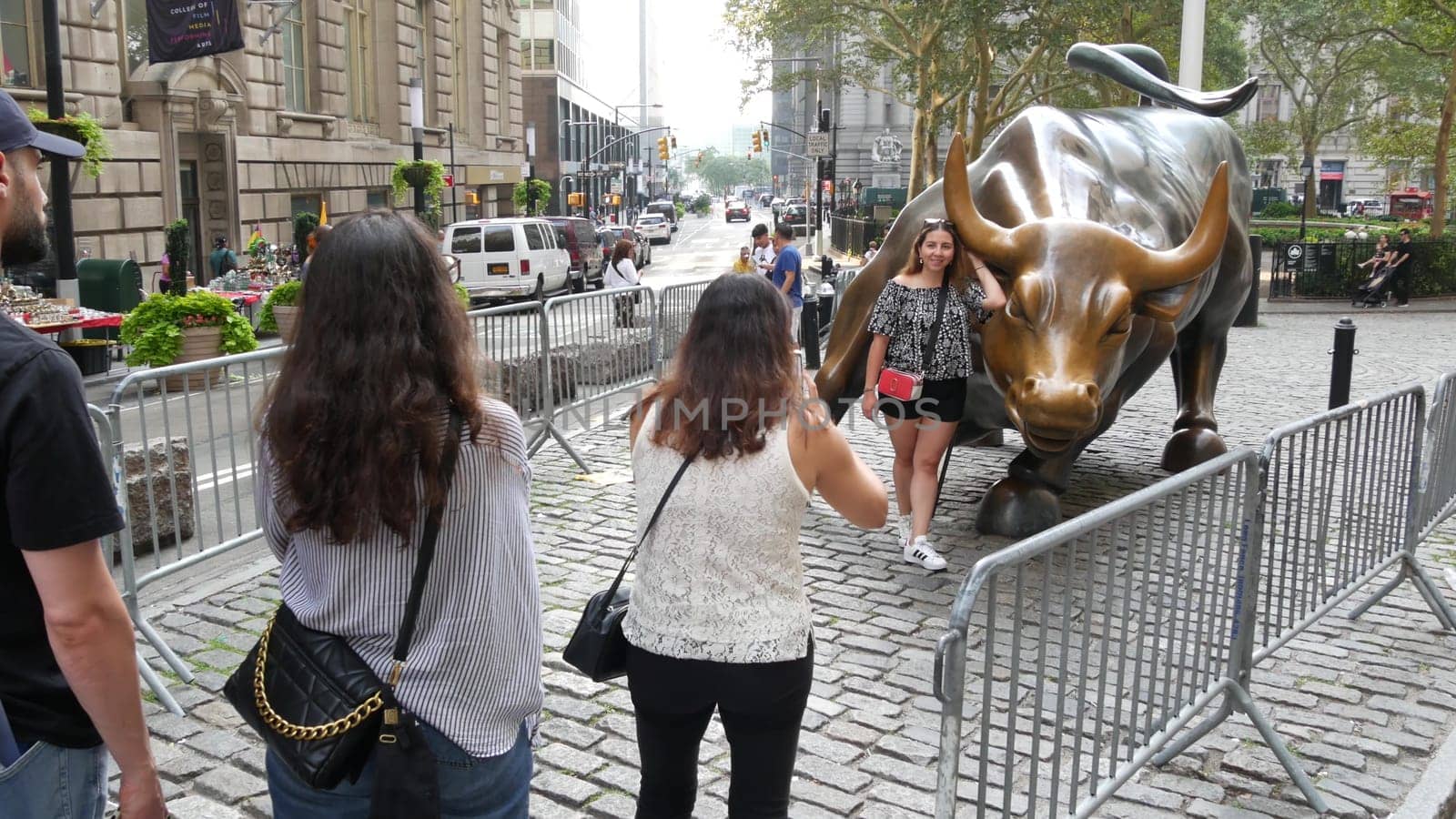 New York City, United States - 9 Sept 2023: Charging Bull, Wall street Stock Exchange symbol in USA. Lower Manhattan Downtown Financial District. American Broadway street. Tourist people photographing