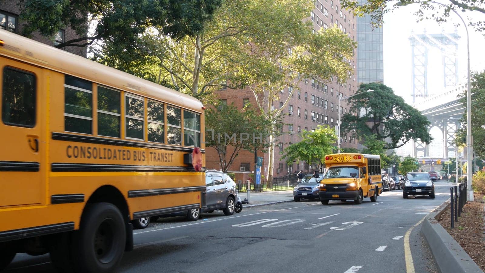 New York City, United States - 7 Sept 2023: Yellow School Bus, Manhattan bridge, schoolbus truck, city street. Children education and USA transportation. American residential district school shuttle.