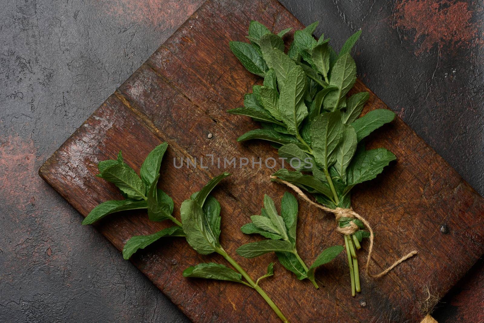 Bunch of fresh green mint on wooden board, top view. Cocktail ingredient