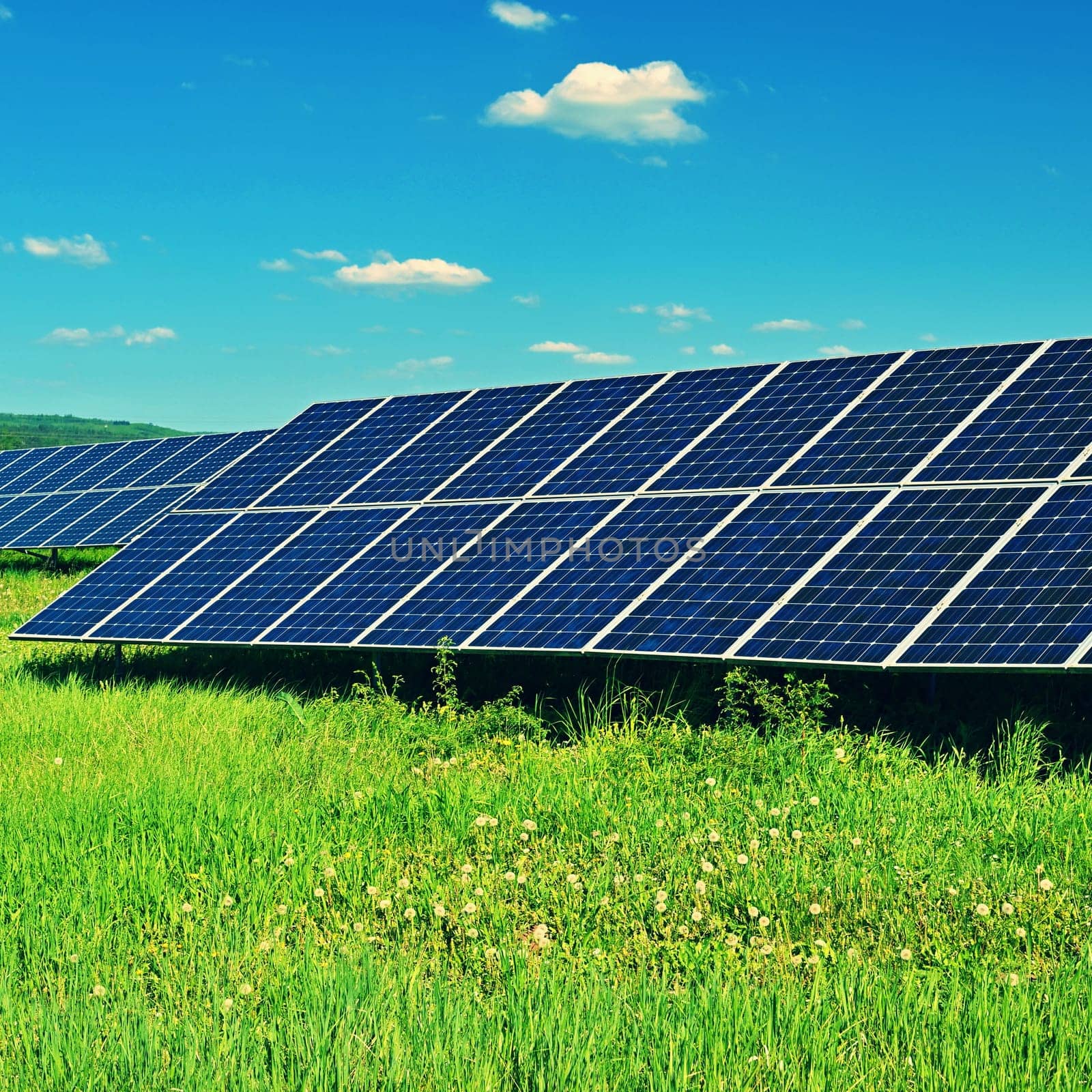 Solar power plant - concept for electricity and ecological industry. High energy prices. Beautiful landscape and sunny day with blue sky. Photovoltaic power plant.