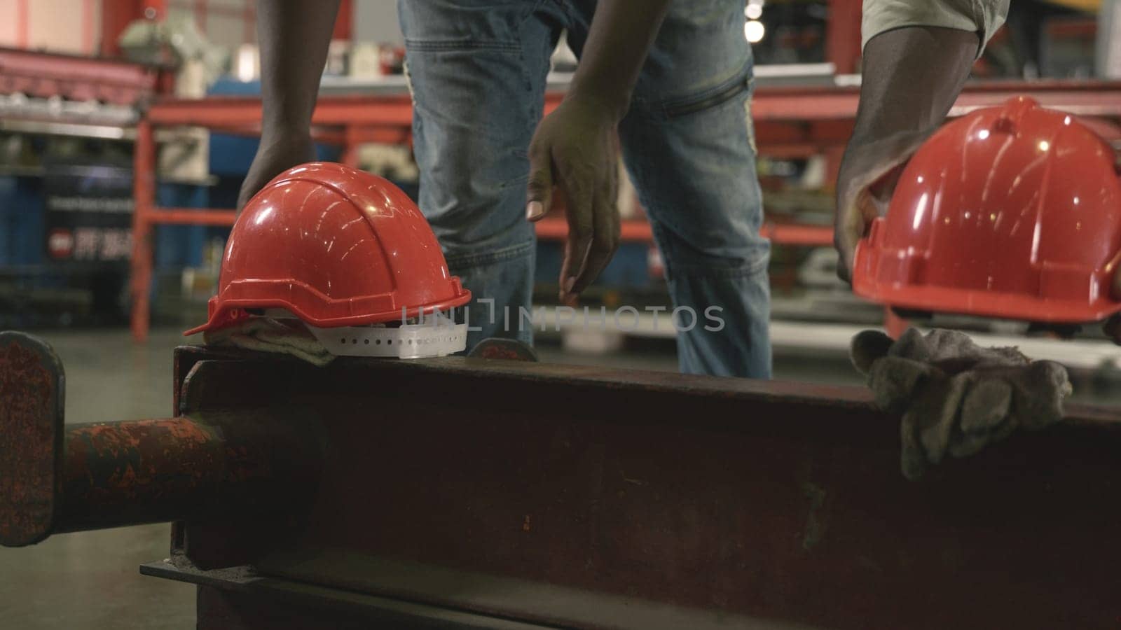 Time toget off from work. factory worker take off helmet put it on a large piece of iron, engineering in uniform walking go back to home