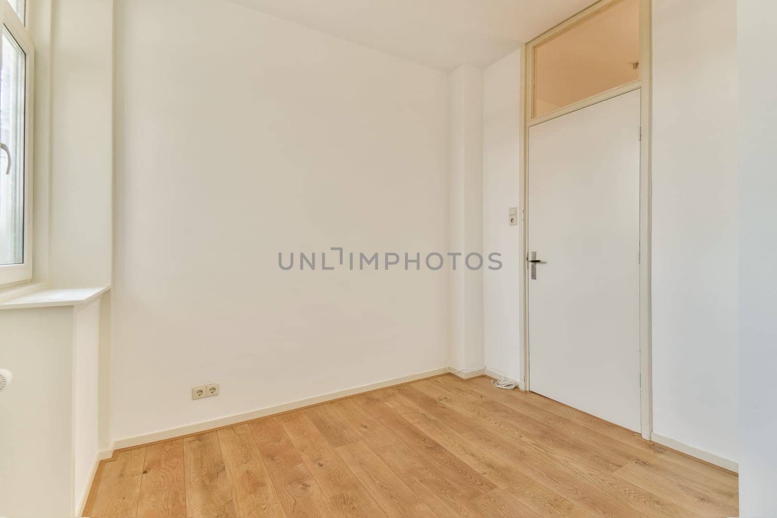 A spacious interior featuring a light color scheme with wooden flooring and a simple doorway. Ideal for minimalist design concepts.