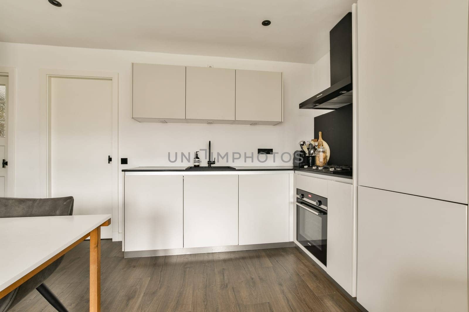 A sleek and functional kitchen featuring a modern design with white cabinetry and contemporary appliances, creating an organized cooking space.