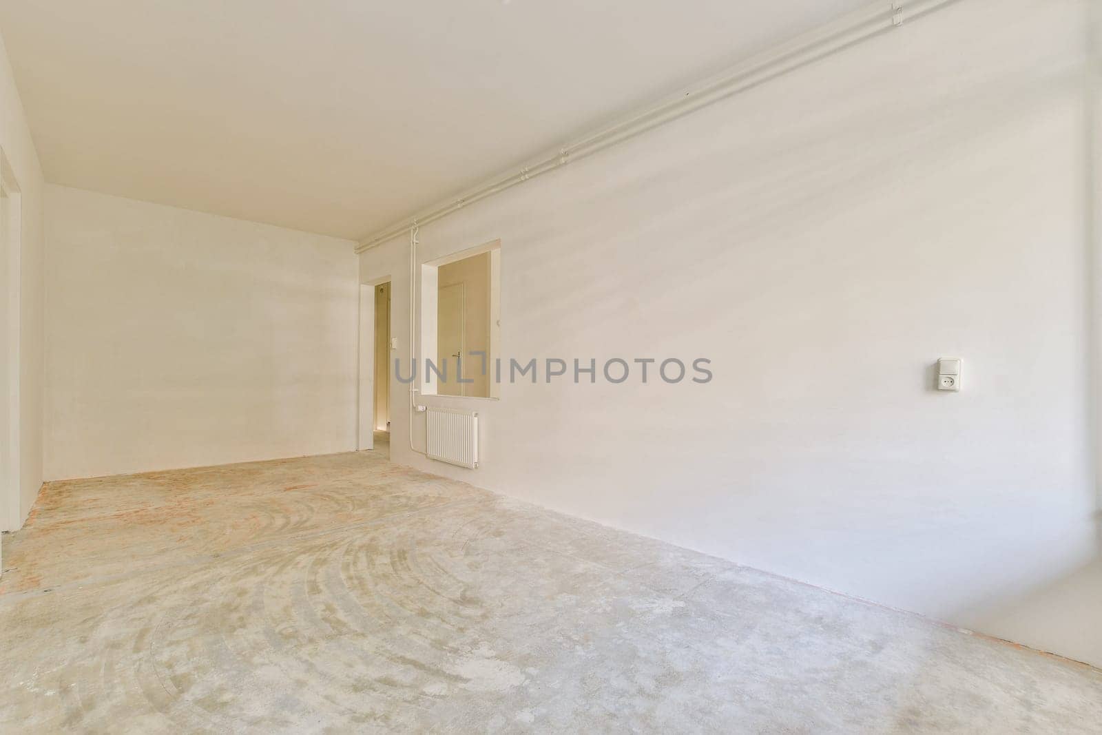 A spacious, undecorated room with plain white walls and a bare floor, ready for interior design or renovation. Ideal for inspiration in minimalist aesthetics.