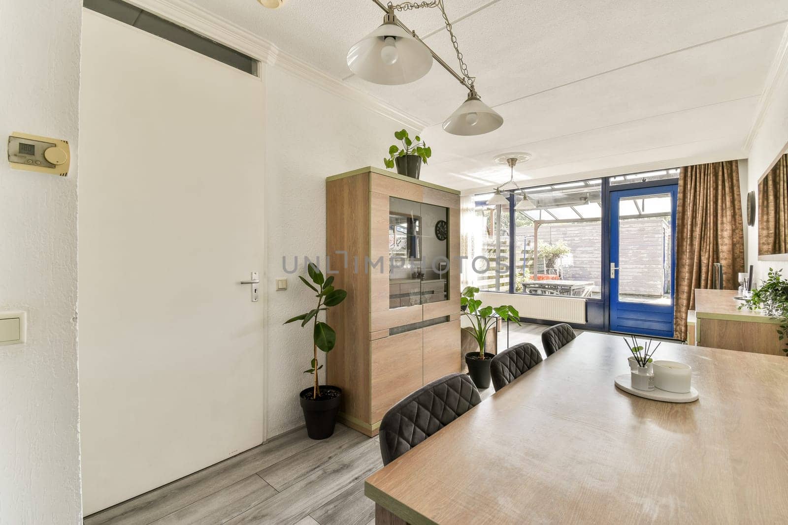 A stylish room showcasing modern furniture, large windows, and plants, emphasizing a bright and airy atmosphere perfect for relaxation and socializing.