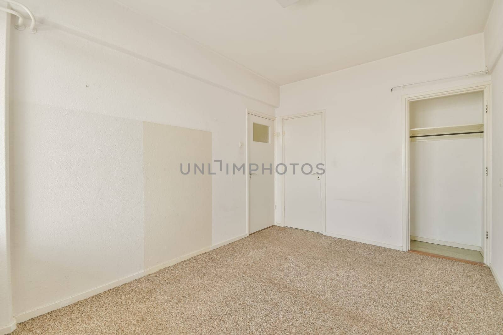 A spacious, uncluttered room featuring light-colored walls, carpeted floor, and a simple closet. Ideal for interior design inspiration or real estate listings.