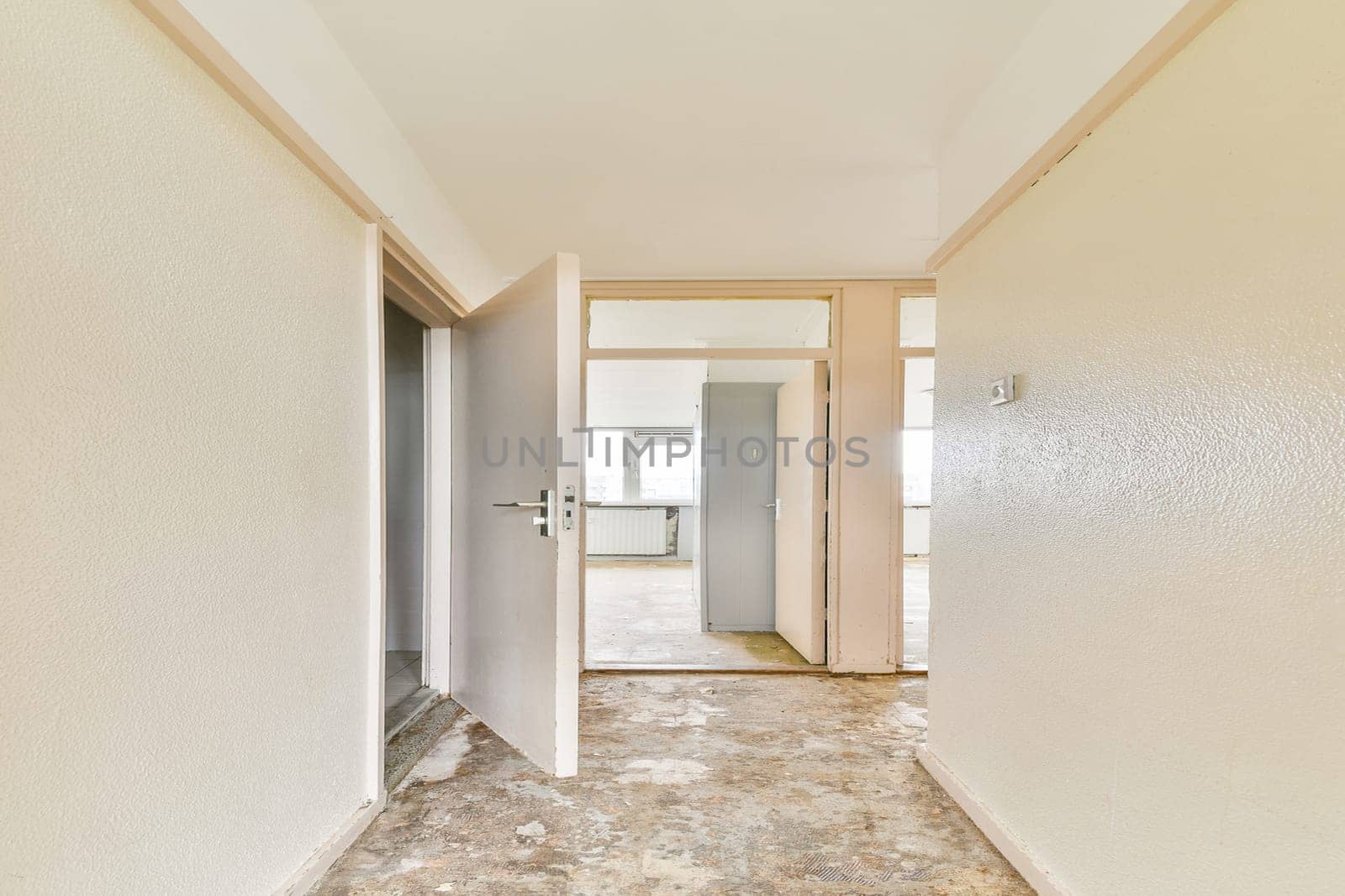 An airy interior hallway featuring light-colored walls and multiple doorways, creating a sense of openness and spaciousness.