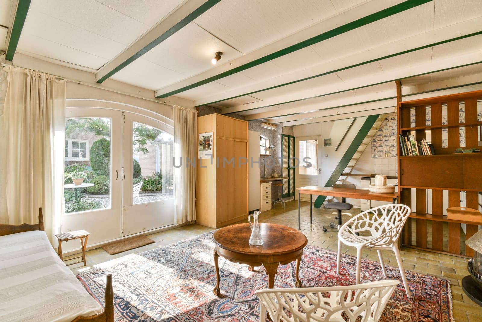 A bright and welcoming interior space featuring wooden beams and elegant furniture. The setting showcases a blend of comfort and style that invites relaxation.