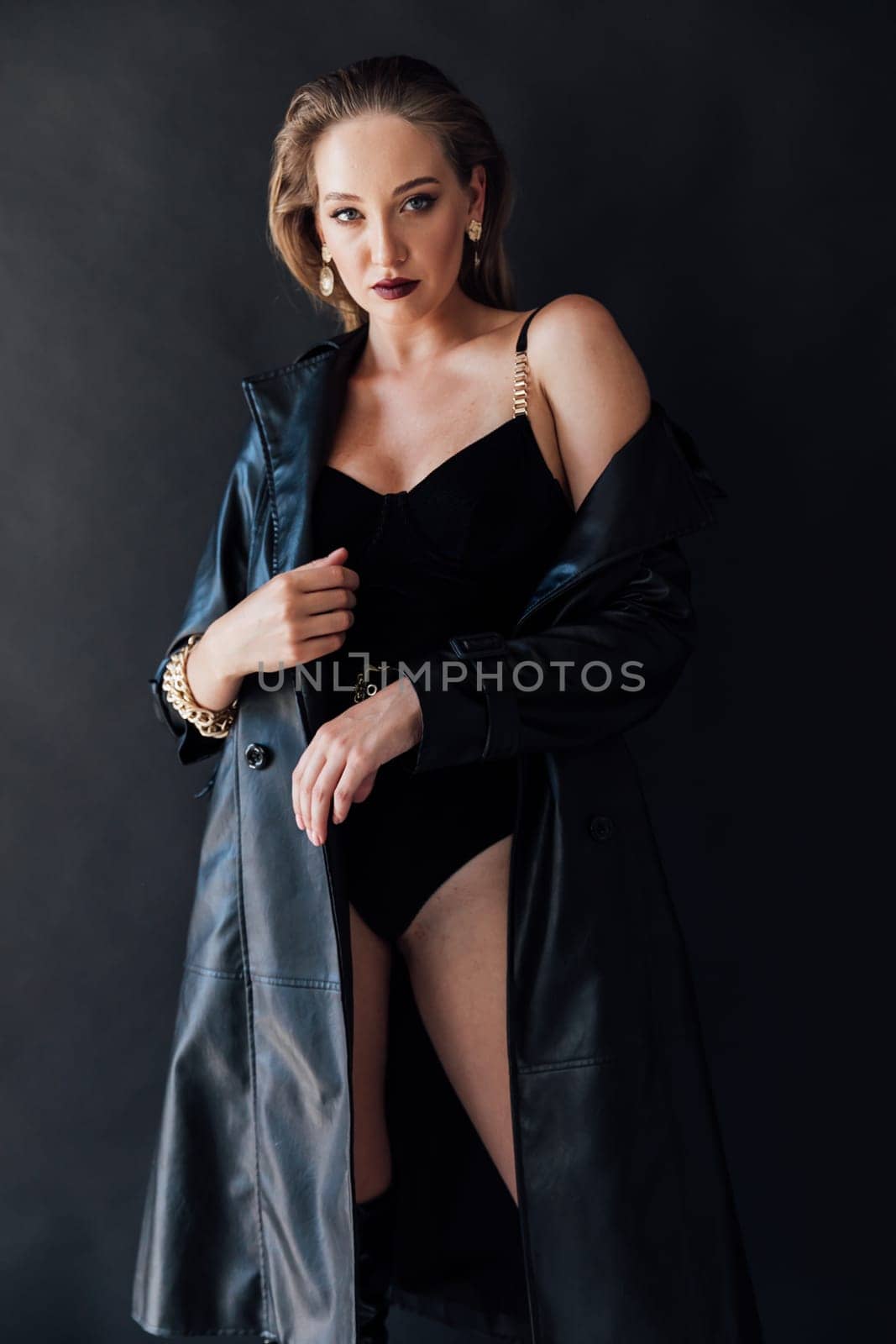 Fashionable slim woman in black leather raincoat and boots