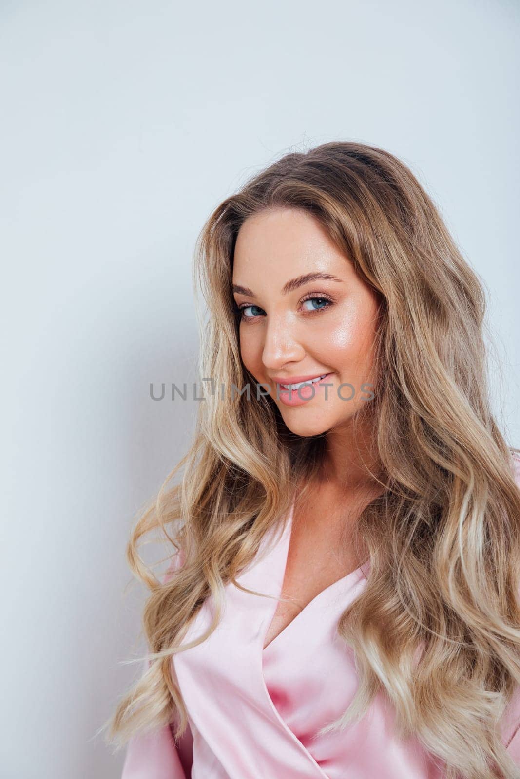 Fashionable woman in summer pink dress smiling on white background