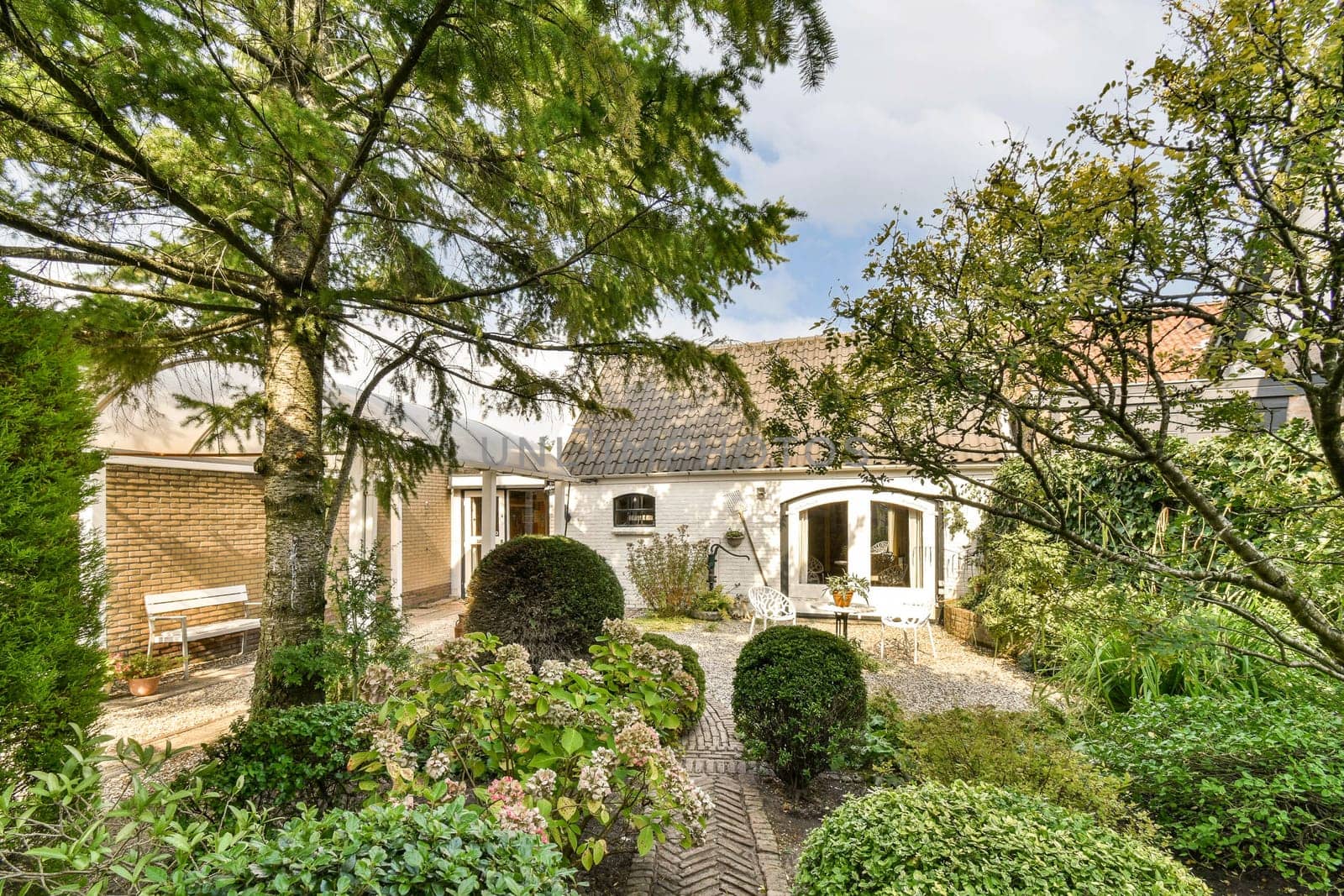 A picturesque garden featuring a variety of plants and trees, creating a tranquil and inviting atmosphere, perfect for relaxation and nature appreciation.