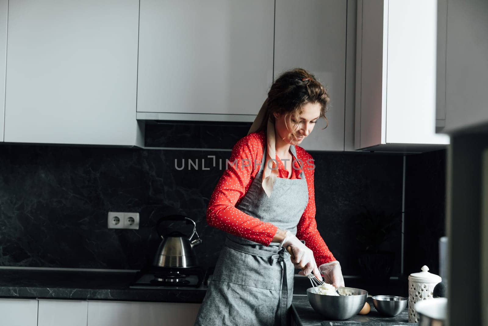 Woman in red dress preparing food in kitchen for dinner