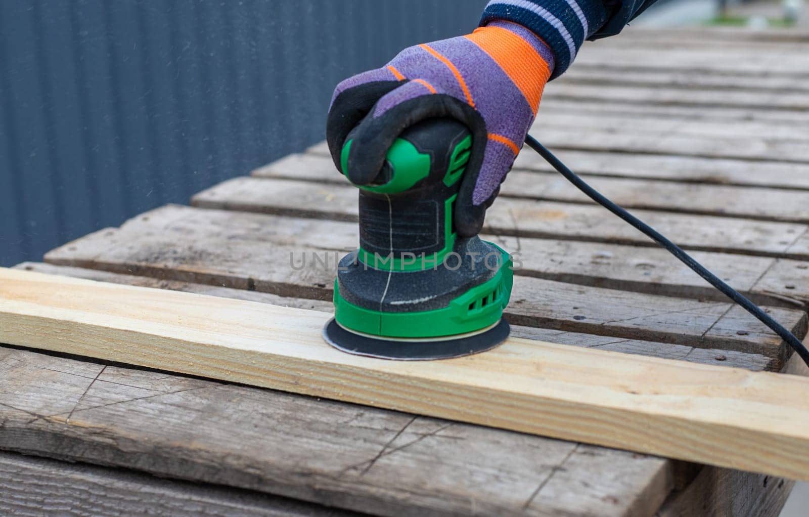 Man sanding wooden boards. Selective focus. People.