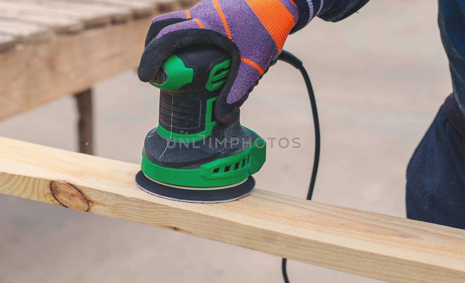 Man sanding wooden boards. Selective focus. People.